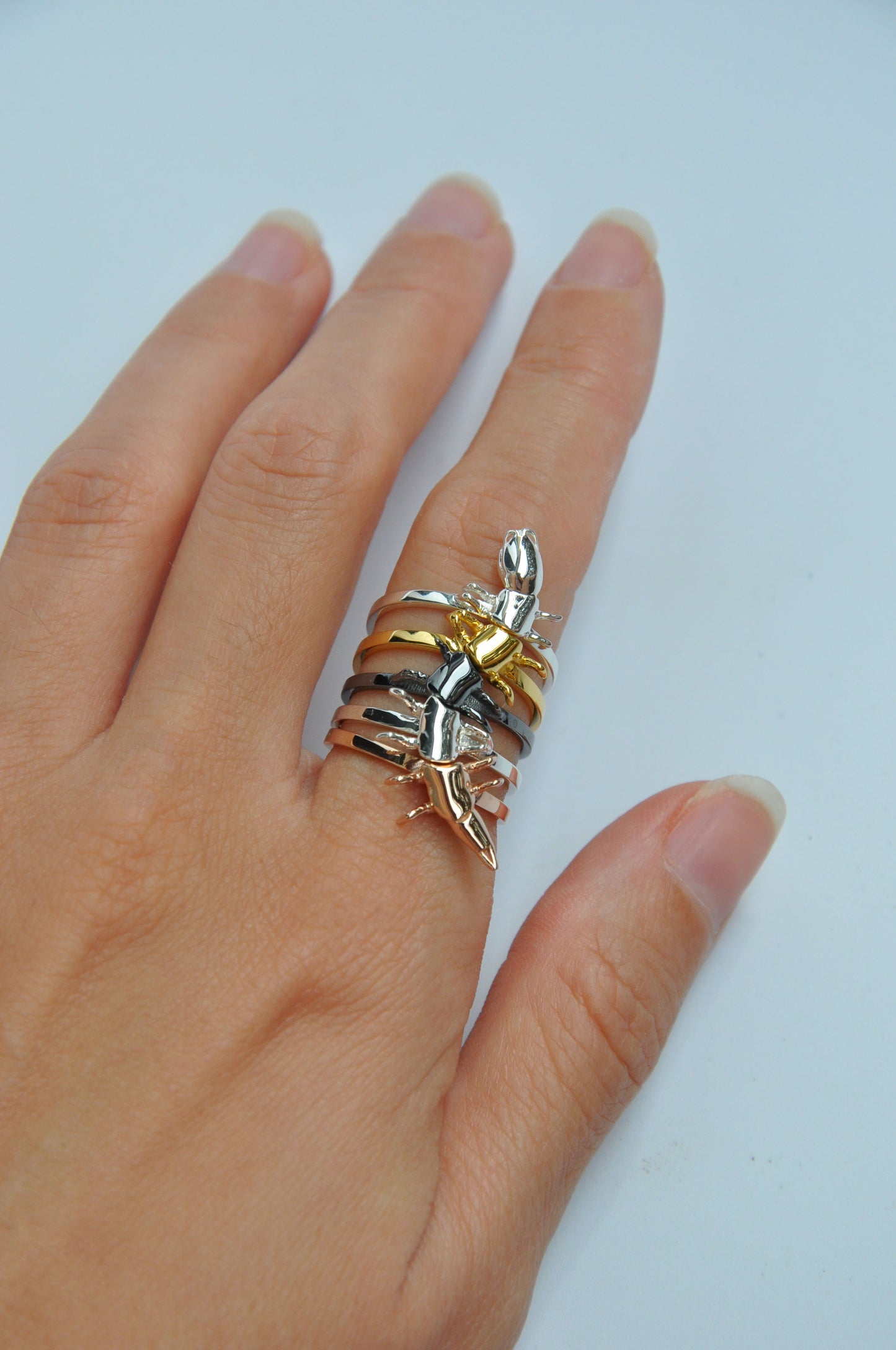 Video of colorful rainbow centipede stacking rings worn on a hand, showcasing flexible movement and iridescent tones.