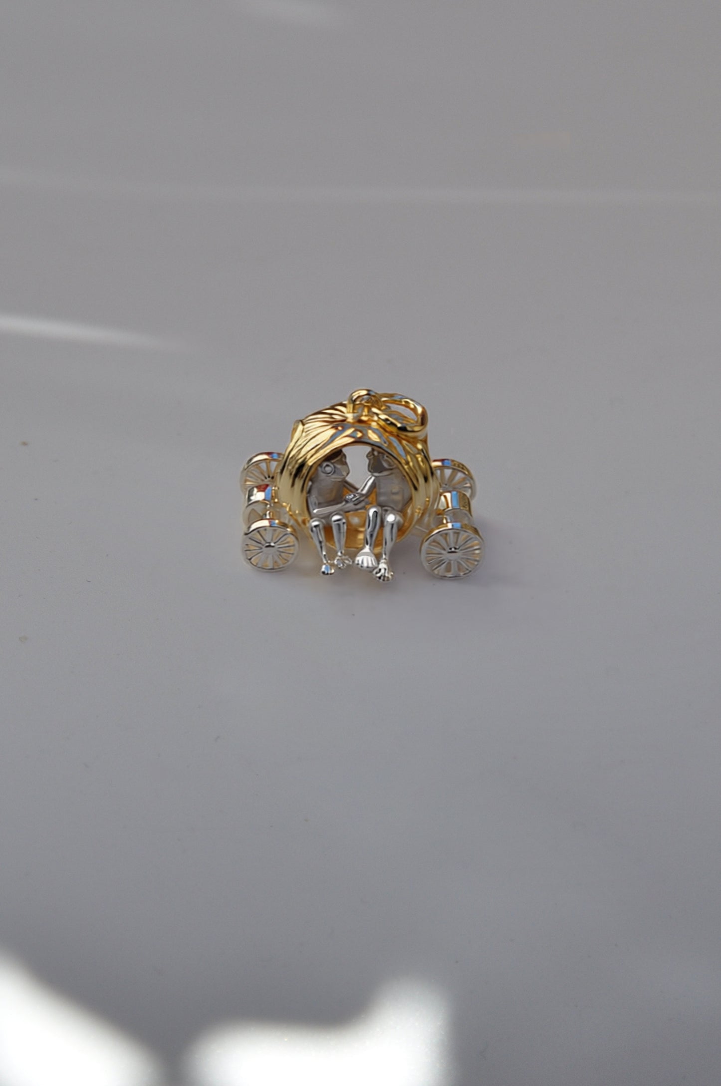 Frogs in Pumpkin Carriage Pendant featuring a gold pumpkin carriage with two silver frogs seated hand‑in‑hand inside.