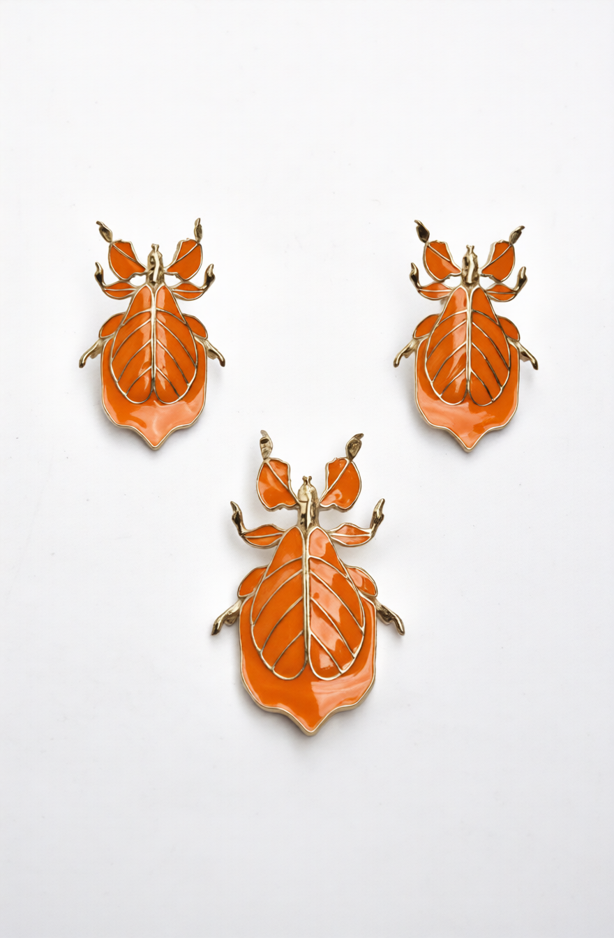 Phylliidae walking-leaf insect stud earrings in vibrant orange enamel with mirror-polished 14k gold-plated finish, handcrafted sculptural botanical jewelry.