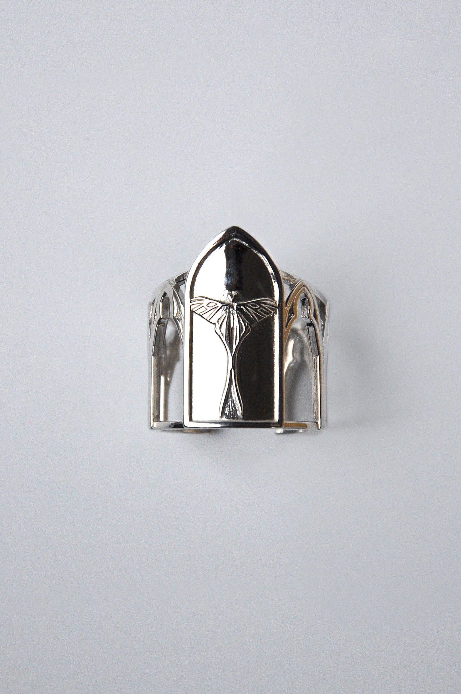 Gothic cathedral-style ring with embossed luna moth on front, titled Sanctuary of Wings, in a modern sculptural design.