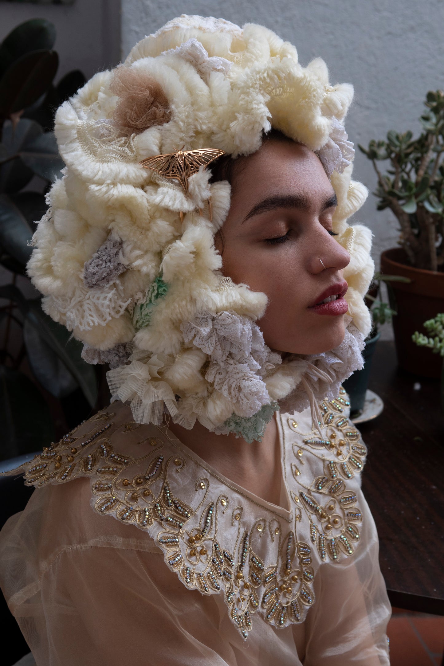Zoomed-out view of a Bronze Luna Moth hair comb styled on a fantasy costume hat, set in a mystical woodland environment with soft, ethereal lighting and nature-inspired textures.