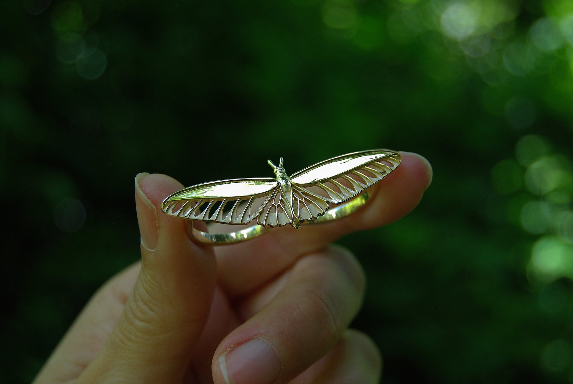 Closeup of 14K gold plated butterfly ring being held, highlighting intricate wing detailing.