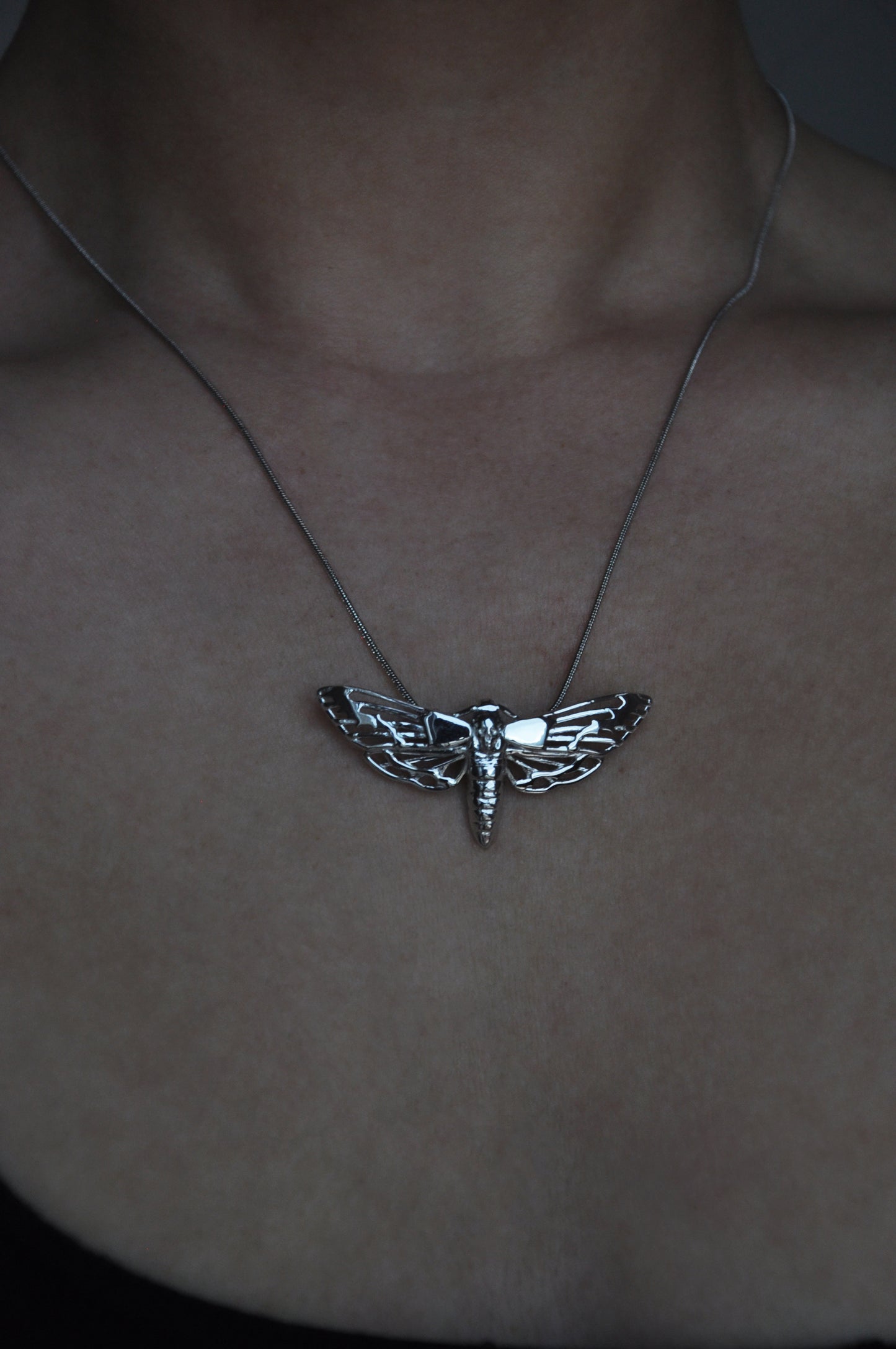 Model wearing the Death’s-head Hawk Moth pendant alone, highlighting the pendant’s detailed design and elegant fit.