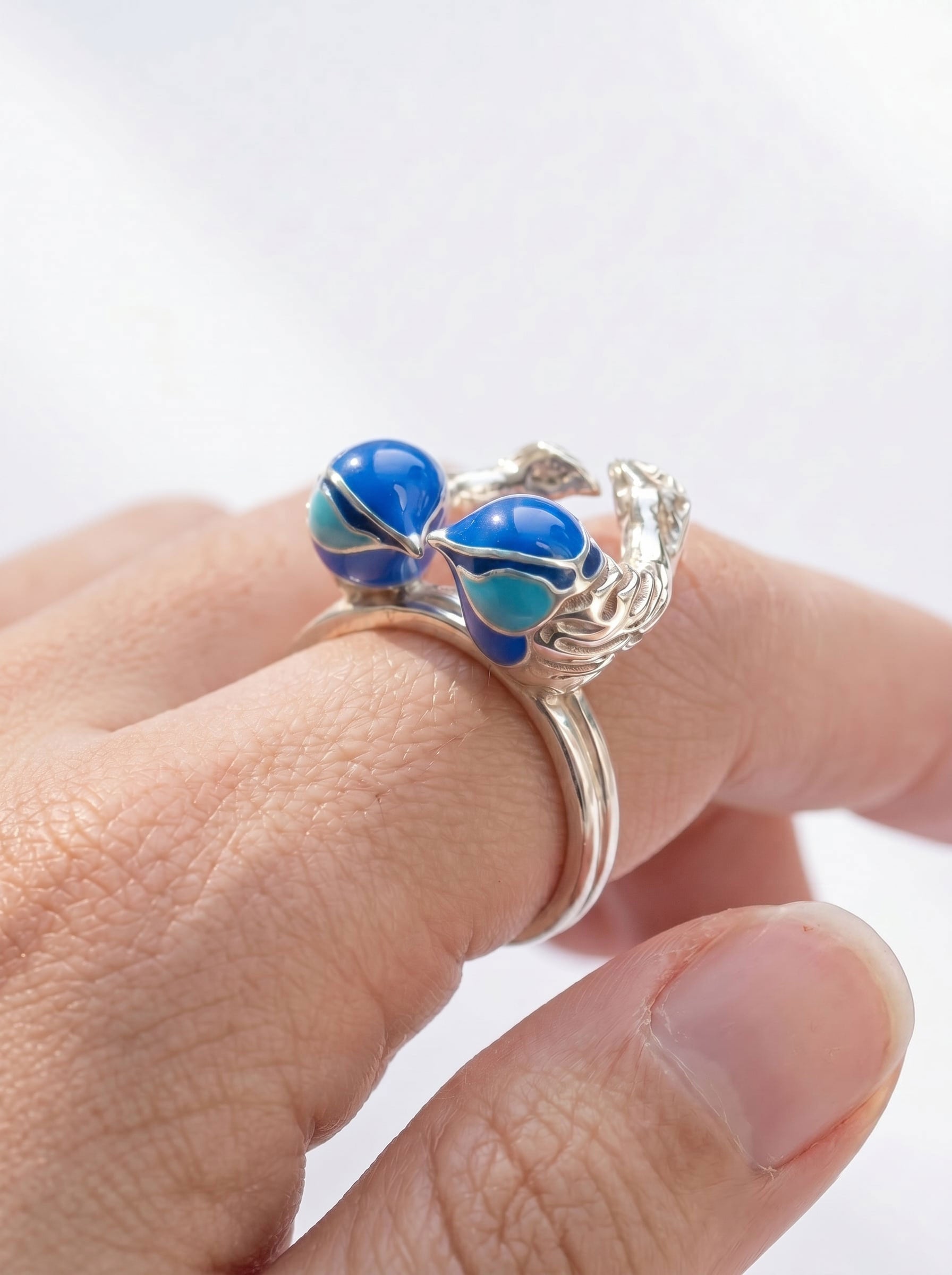 Angled view of Fairy Wren stacking rings on hand, capturing the mirrored bird forms and subtle heart shape.