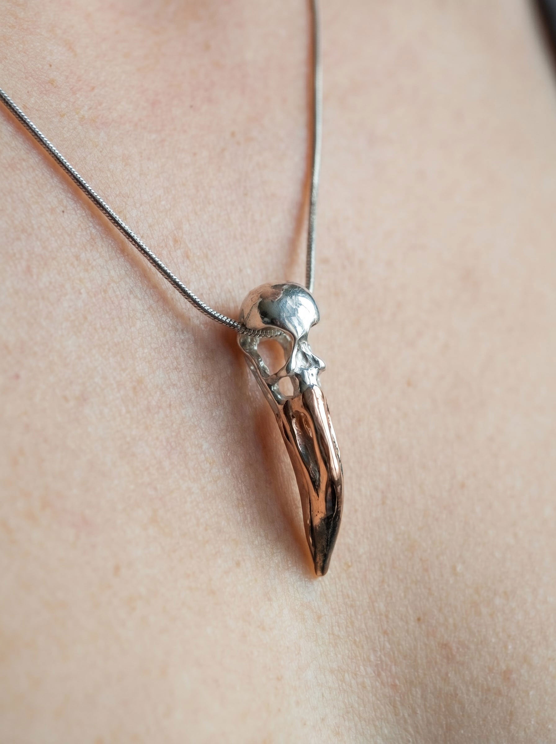 Flamingo Skull Pendant worn on neck, highlighting polished surfaces and delicate anatomical geometry.