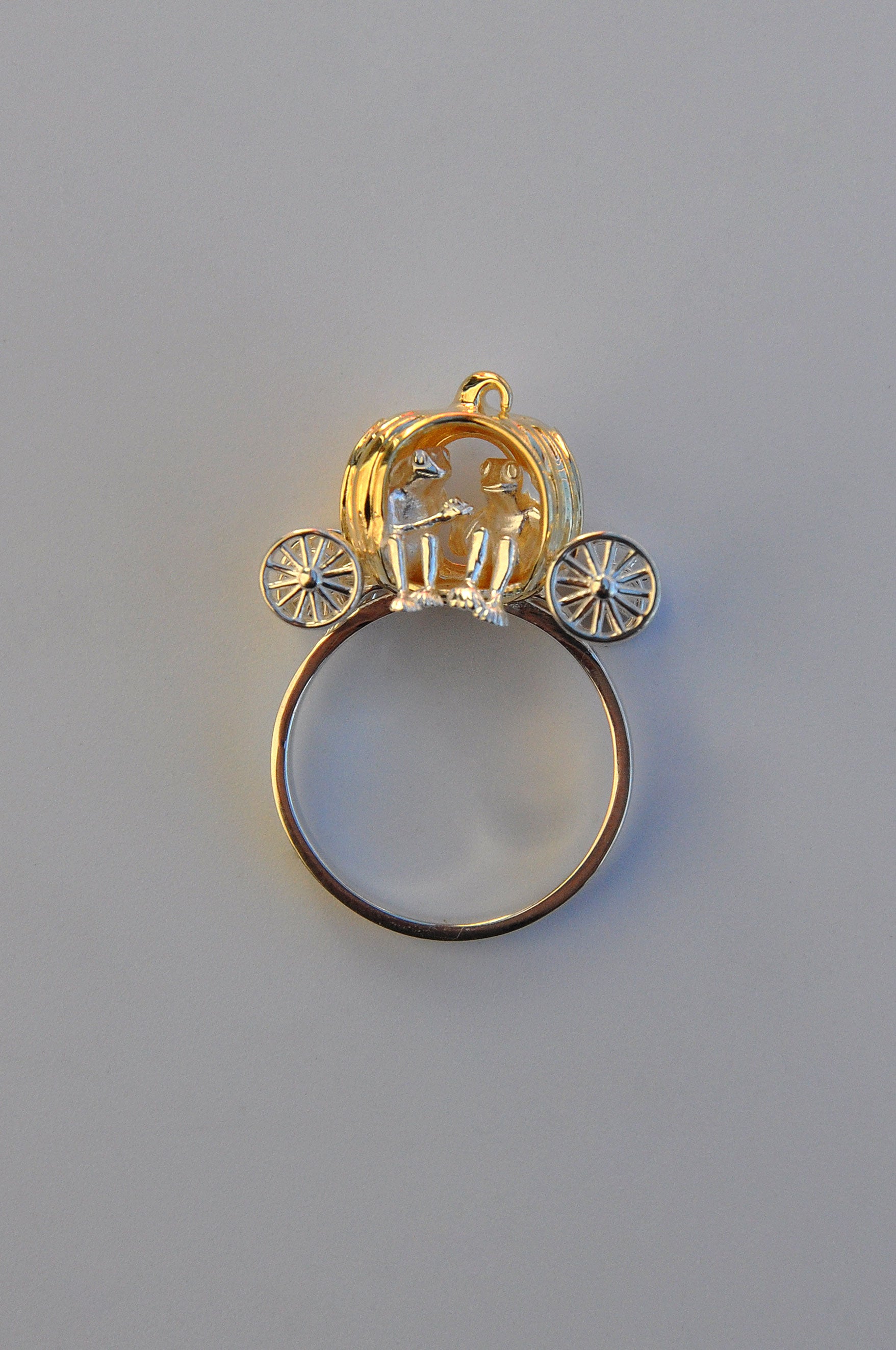 Frogs in Pumpkin Carriage Ring featuring two tiny frogs inside a sculpted pumpkin carriage with spinning wheels and curling root arms.