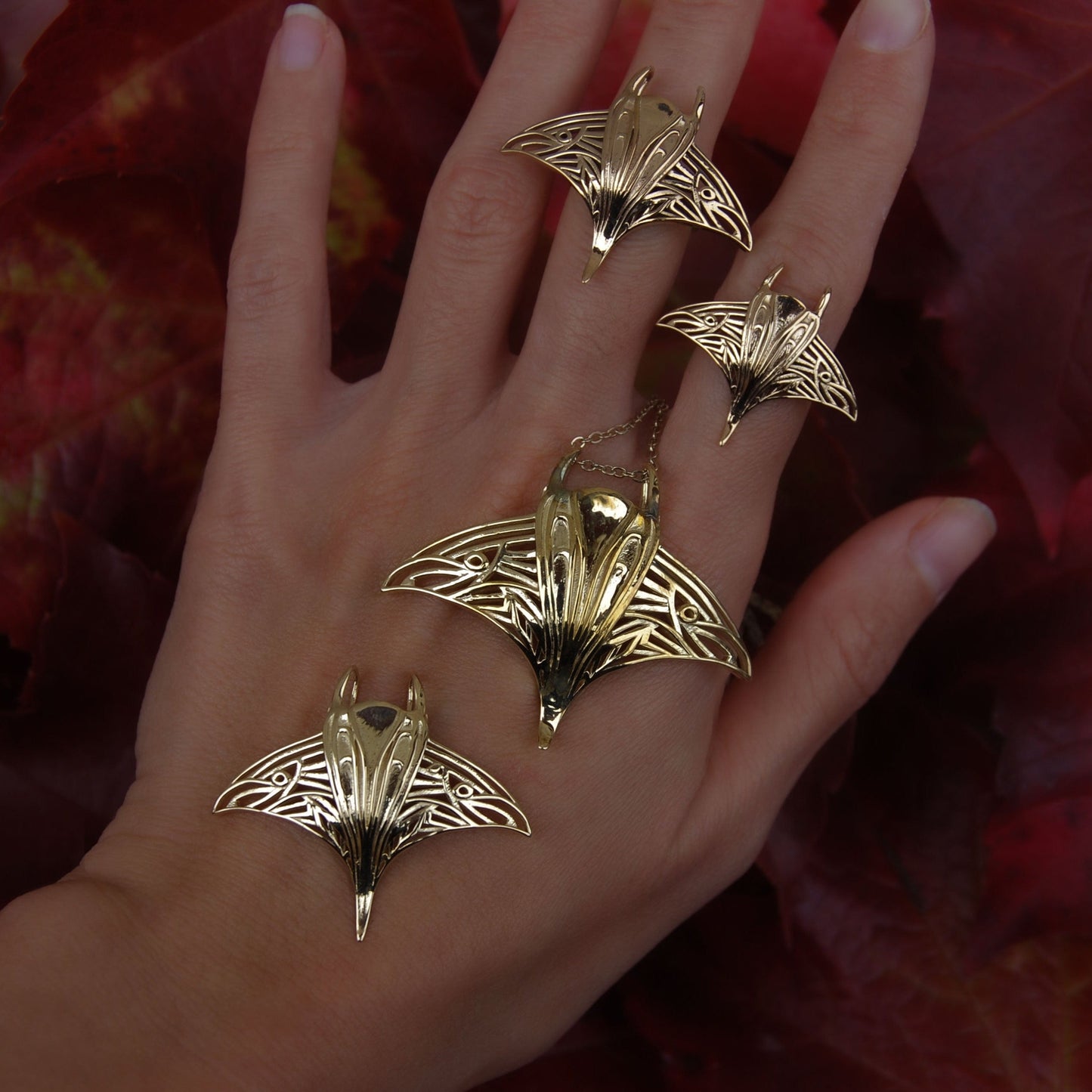 Gold manta ray ring and matching pendant displayed on hand, highlighting marine life jewelry set.