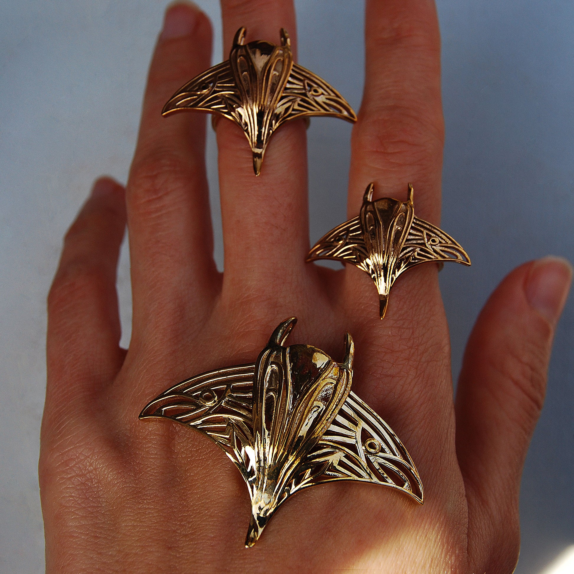 Gold manta ray ring and pendant worn together on hand, highlighting ocean-inspired jewelry craftsmanship.