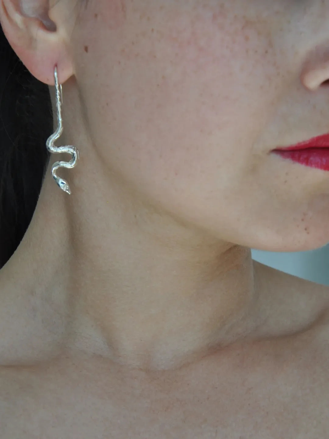 Handcrafted silver snake earring with asymmetrical design inspired by botanical motifs and Italian craftsmanship.