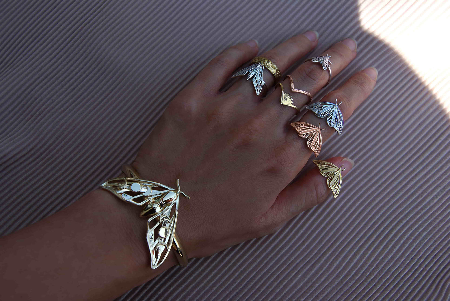 Hawk Moth Bracelet worn by model with celestial stacking rings, styled as symbolic insect and moon phase jewelry.