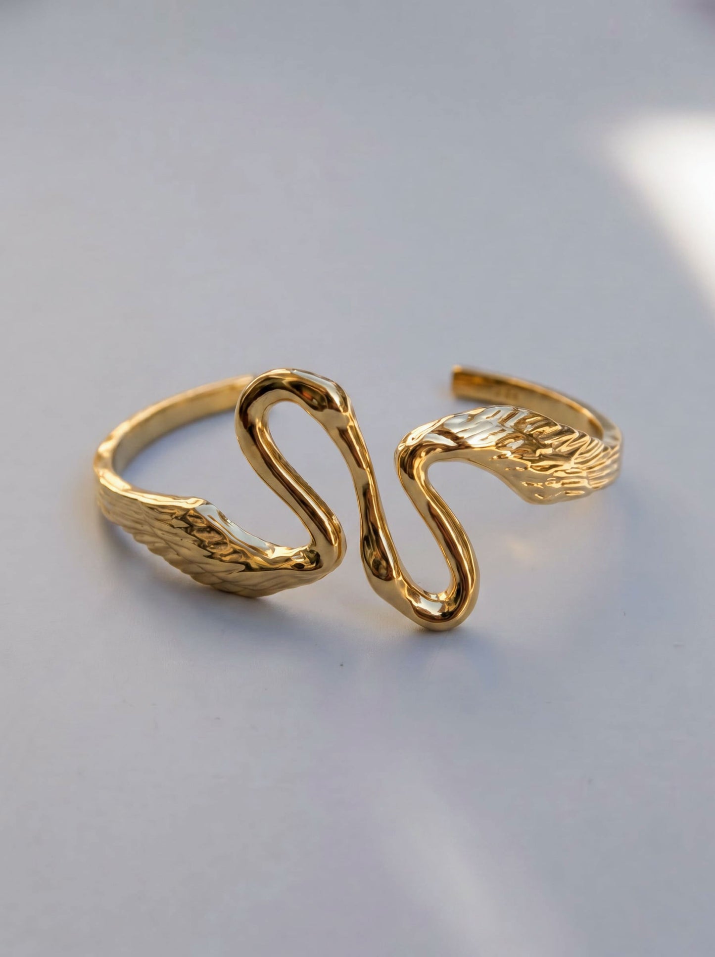 Angled view of Heron Kiss Bracelet Cuff in gold, highlighting fluid Art Nouveau curves and polished surfaces that reflect light like water.