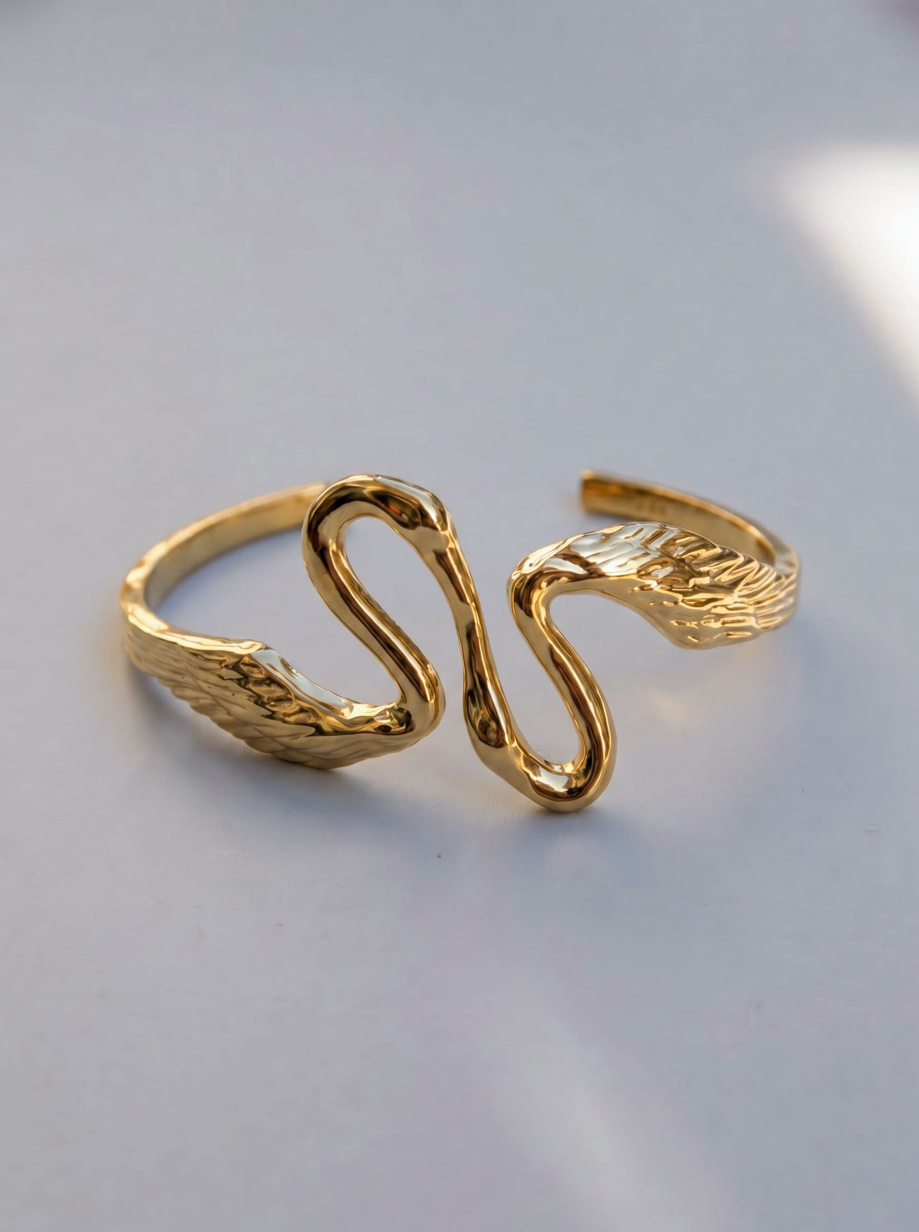 Angled view of Heron Kiss Bracelet Cuff in gold, highlighting fluid Art Nouveau curves and polished surfaces that reflect light like water.