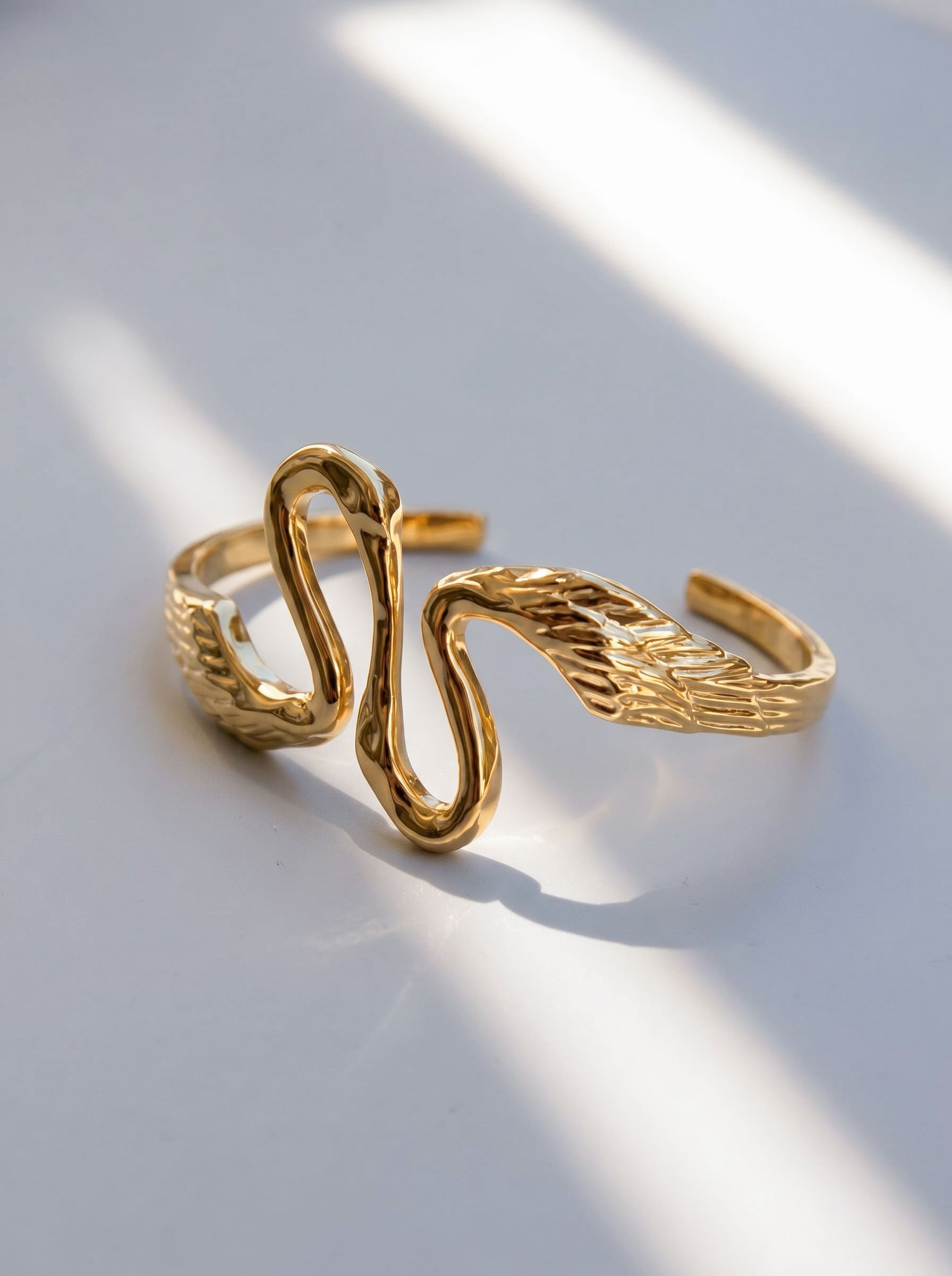 Heron Kiss Bracelet Cuff photographed with soft shadows, emphasizing feathered texture and architectural movement.