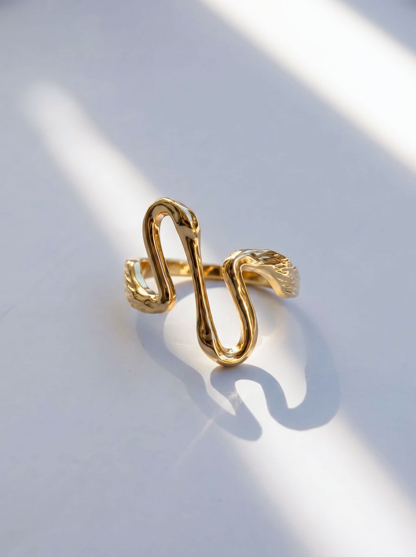 Heron Kiss Rings in silver and gold finishes photographed side by side, capturing mirrored design and sculptural elegance.