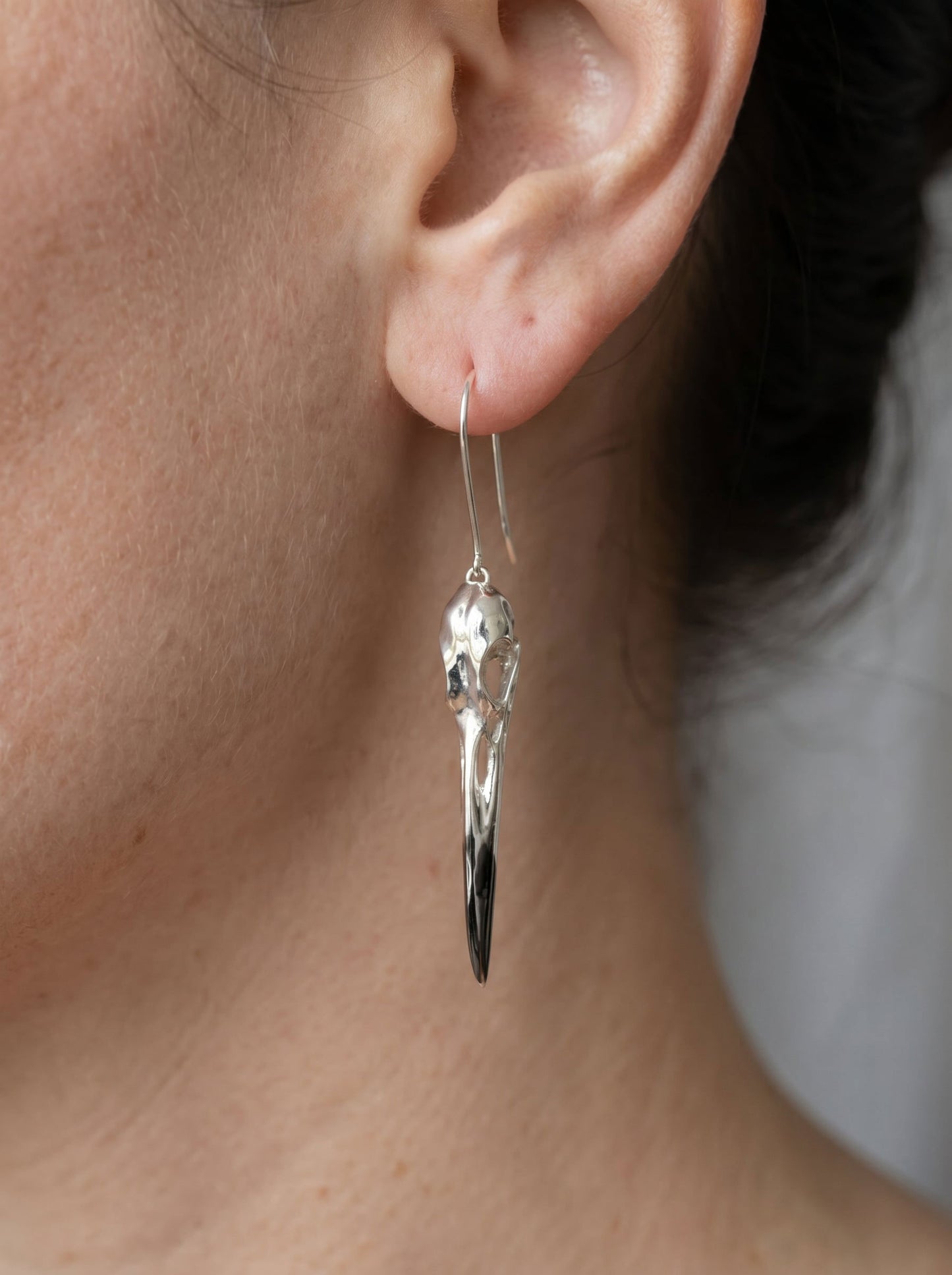Heron Skull Earrings worn in soft natural light, emphasizing sculptural taper and refined Art Nouveau influence.