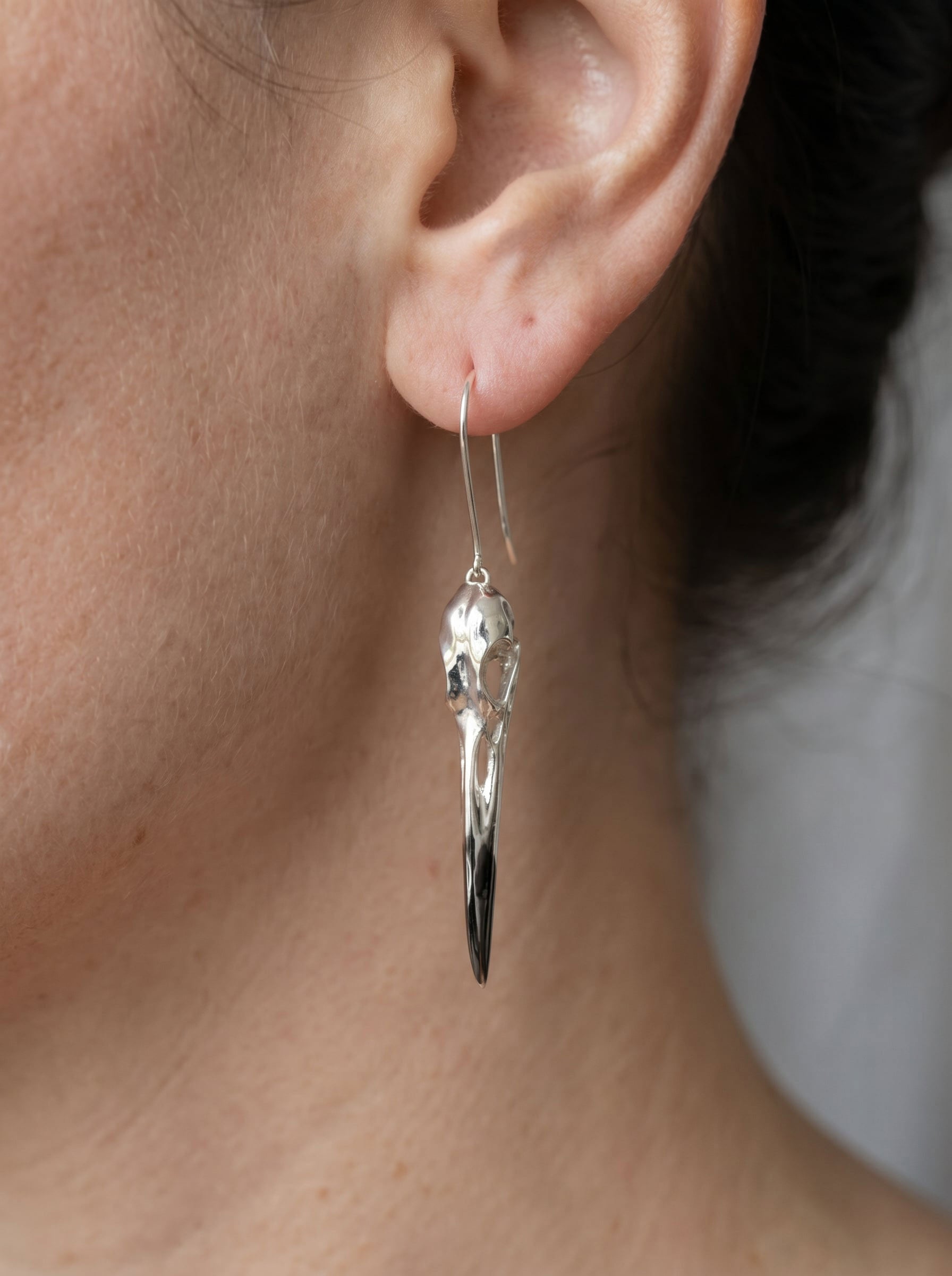 Heron Skull Earrings worn in soft natural light, emphasizing sculptural taper and refined Art Nouveau influence.