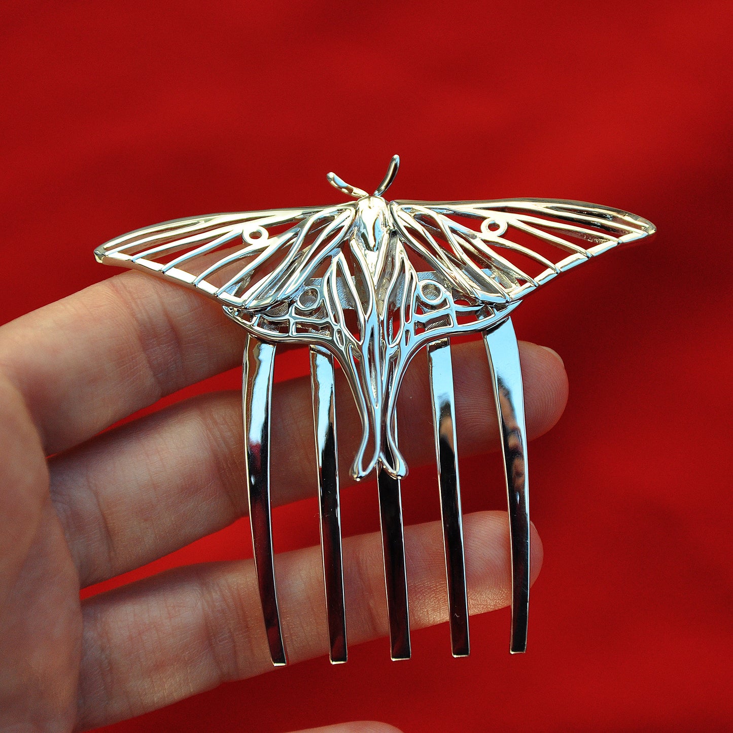 Angled side view of rhodium-plated silver Luna Moth hair comb showcasing detailed wing cutouts and elegant insect-inspired hair jewelry design.