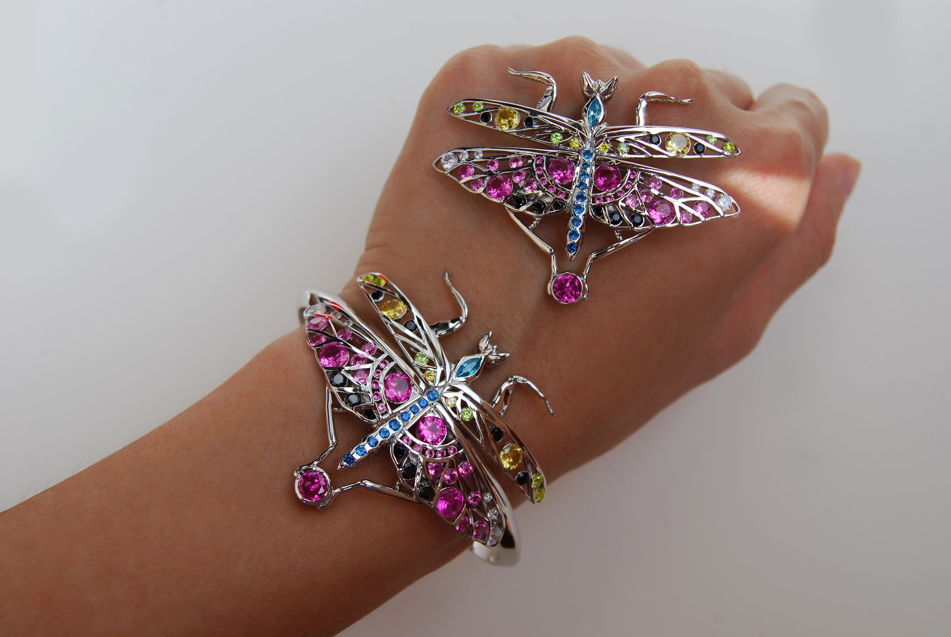 Silver praying mantis pendant and matching bracelet displayed on hand against white background, showcasing detailed insect-inspired design and polished finish