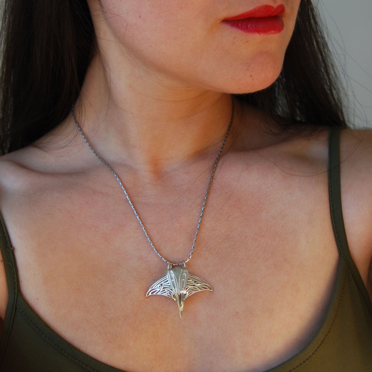 Model wearing sterling silver manta ray pendant, highlighting marine life jewelry design.