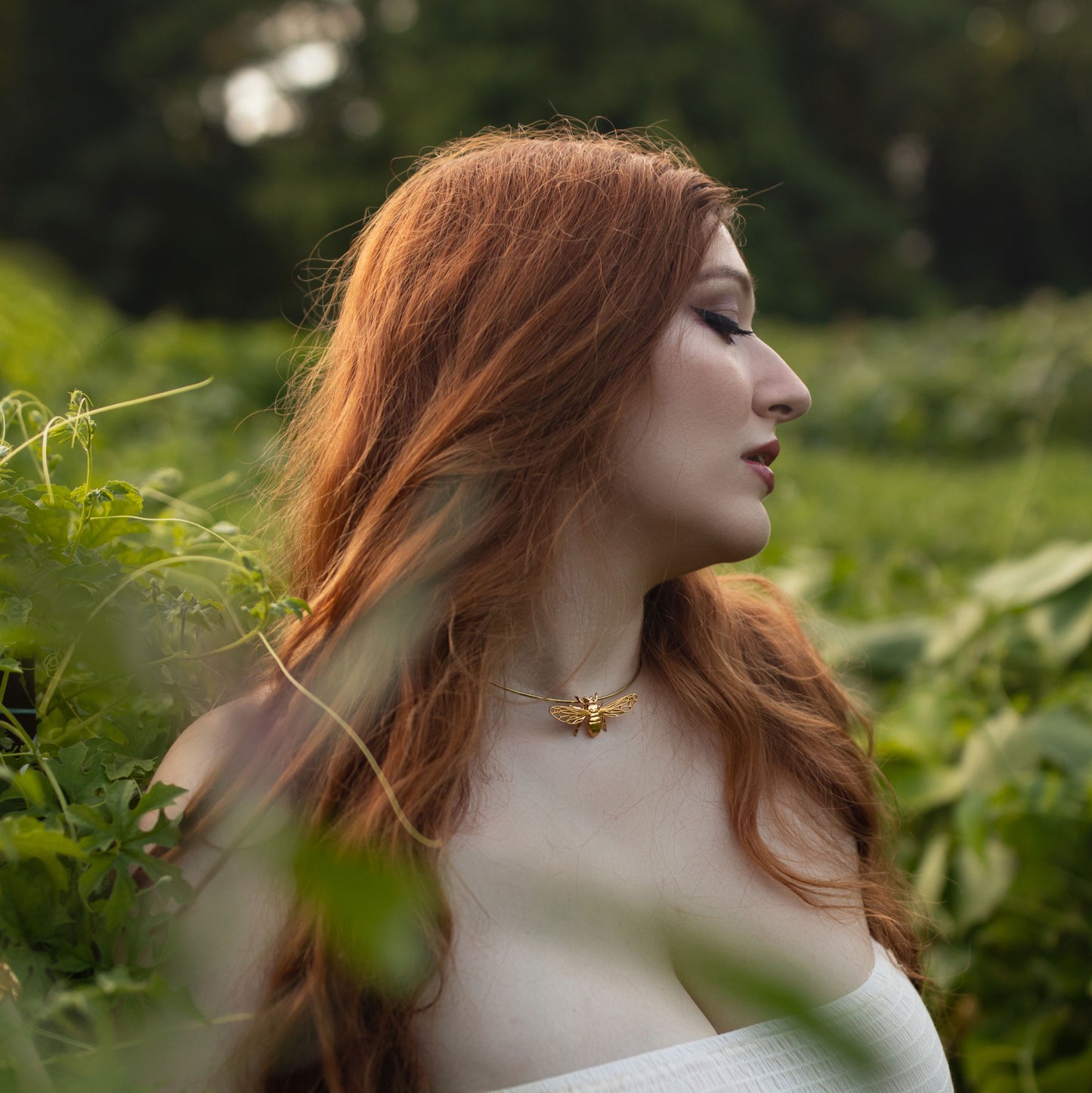 Model wearing silver and gold bee pendant necklace shown in full upper body