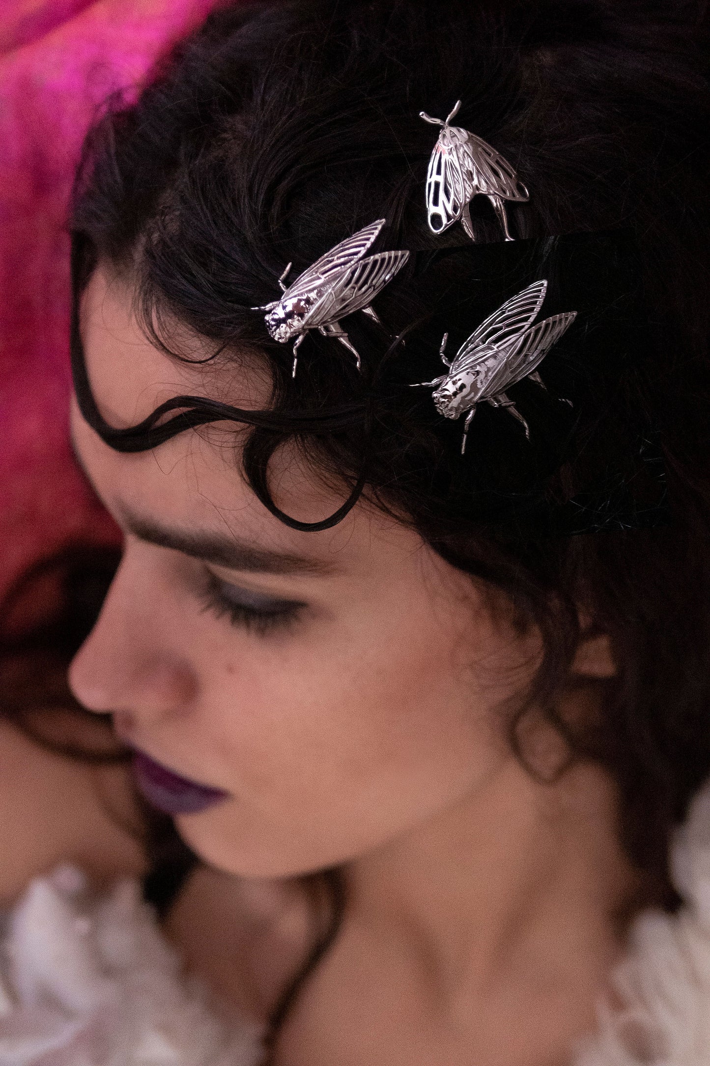 Model wearing silver Cicada hair pins and a Tiger Moth hair accessory, styled in a nature-inspired look that highlights handcrafted insect jewelry with metallic finishes.