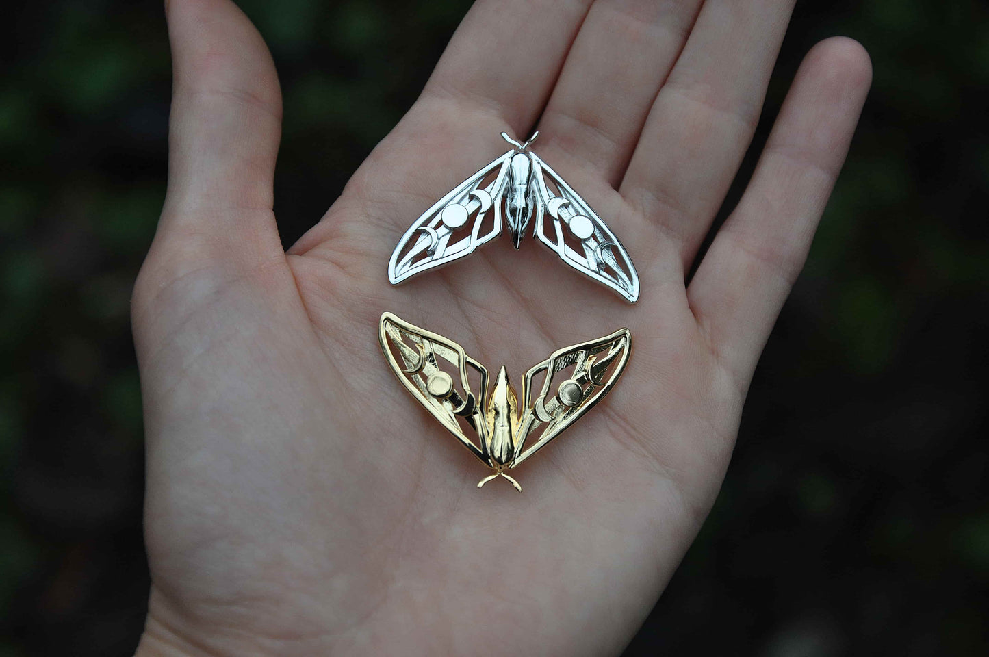 Close-up of model wearing the silver Hawk Moth Pendant, highlighting moon phase details and handcrafted artistry.