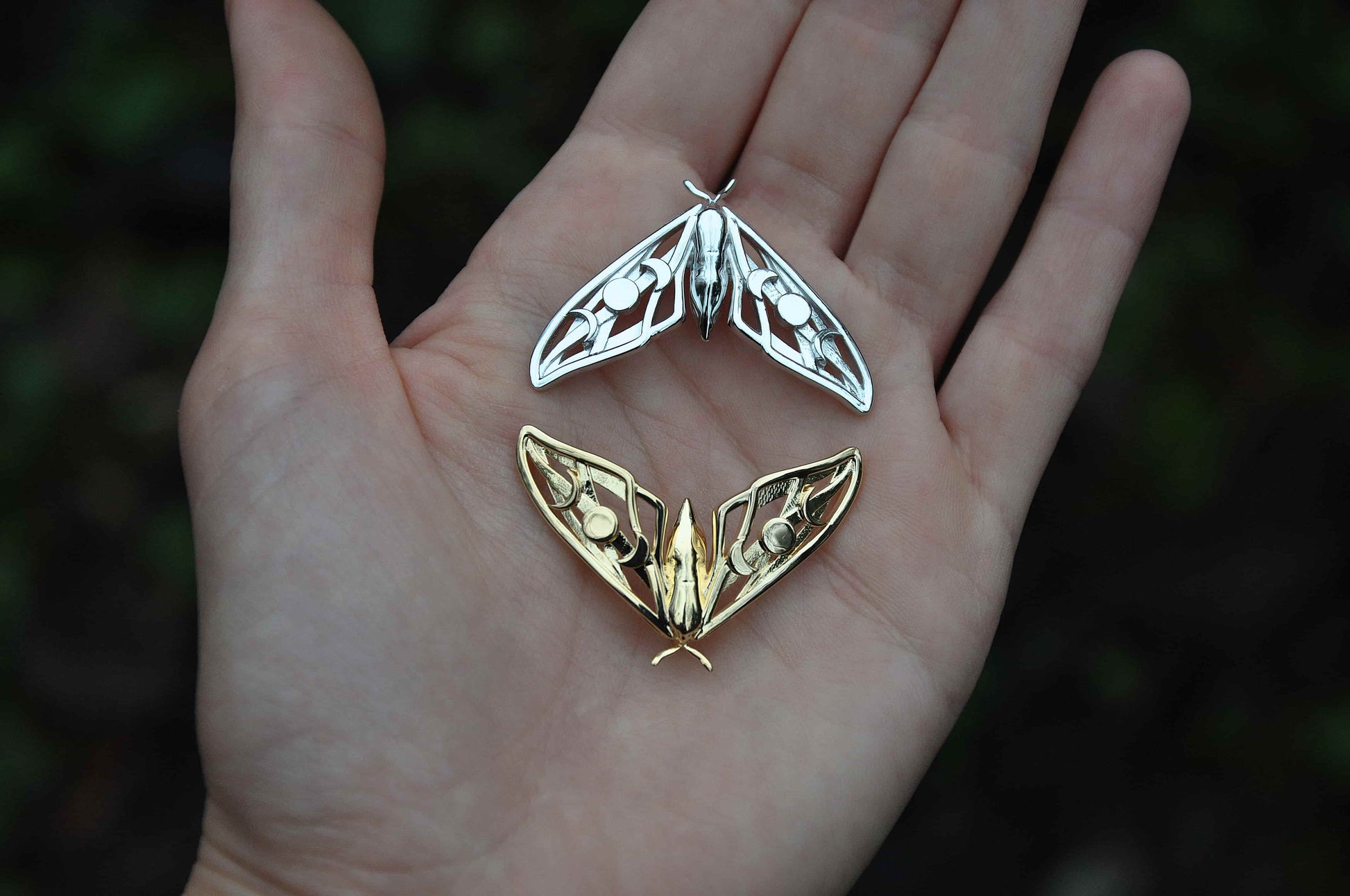 Close-up of model wearing the silver Hawk Moth Pendant, highlighting moon phase details and handcrafted artistry.