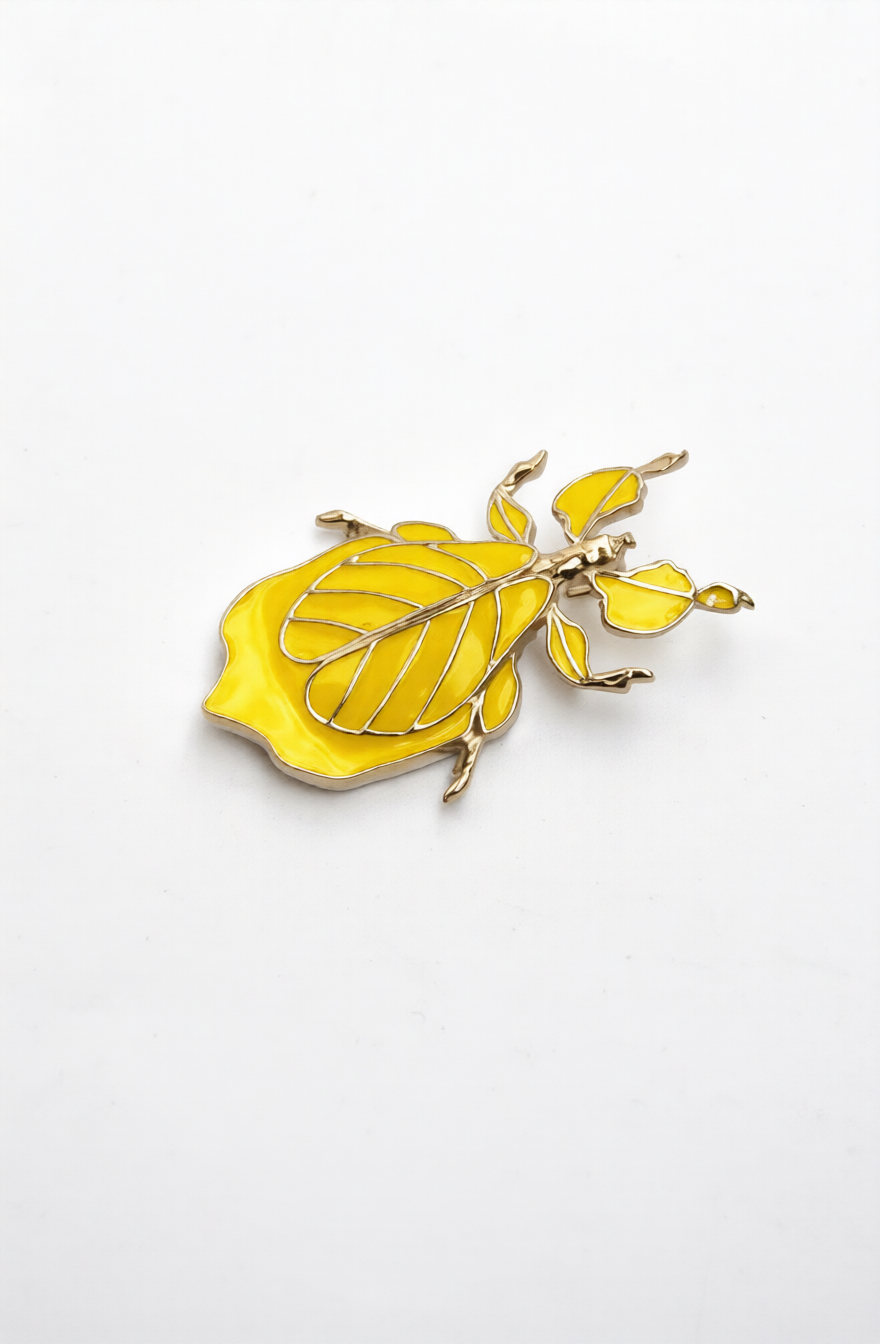 Phylliidae leaf insect pendant in warm yellow hand-applied enamel with 14k gold-plated finish, mirror-polished miniature wearable sculpture inspired by walking-leaf insect camouflage.