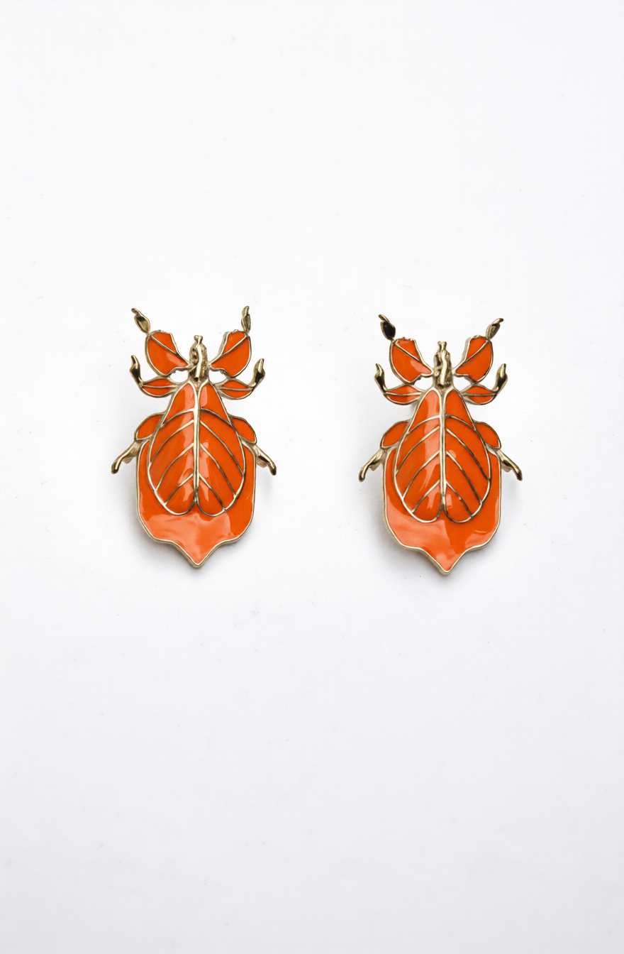 Pair of orange enamel Phylliidae leaf‑insect stud earrings with gold outlines and botanical leaf‑vein design