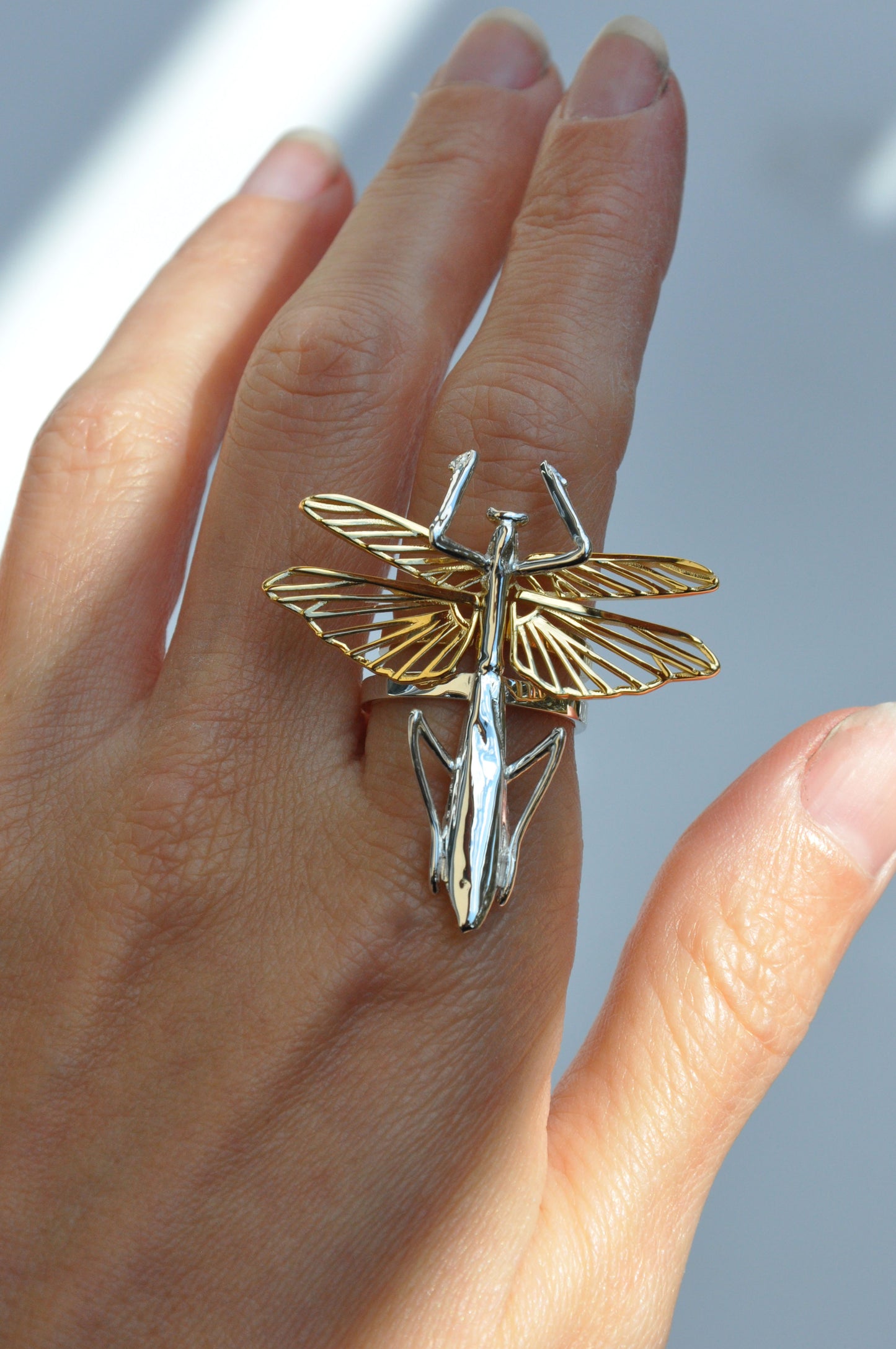Praying mantis stacking ring set with modular torso ring in sterling silver and wings ring in 14k gold plated worn together on the hand.