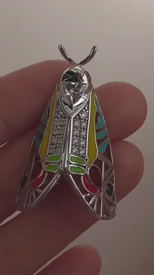 Video of handcrafted Picasso Moth pendant featuring colorful enamel, zirconia stones, and sterling silver design inspired by Baorisa hieroglyphica
