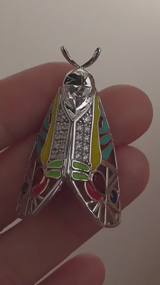 Video of handcrafted Picasso Moth pendant featuring colorful enamel, zirconia stones, and sterling silver design inspired by Baorisa hieroglyphica