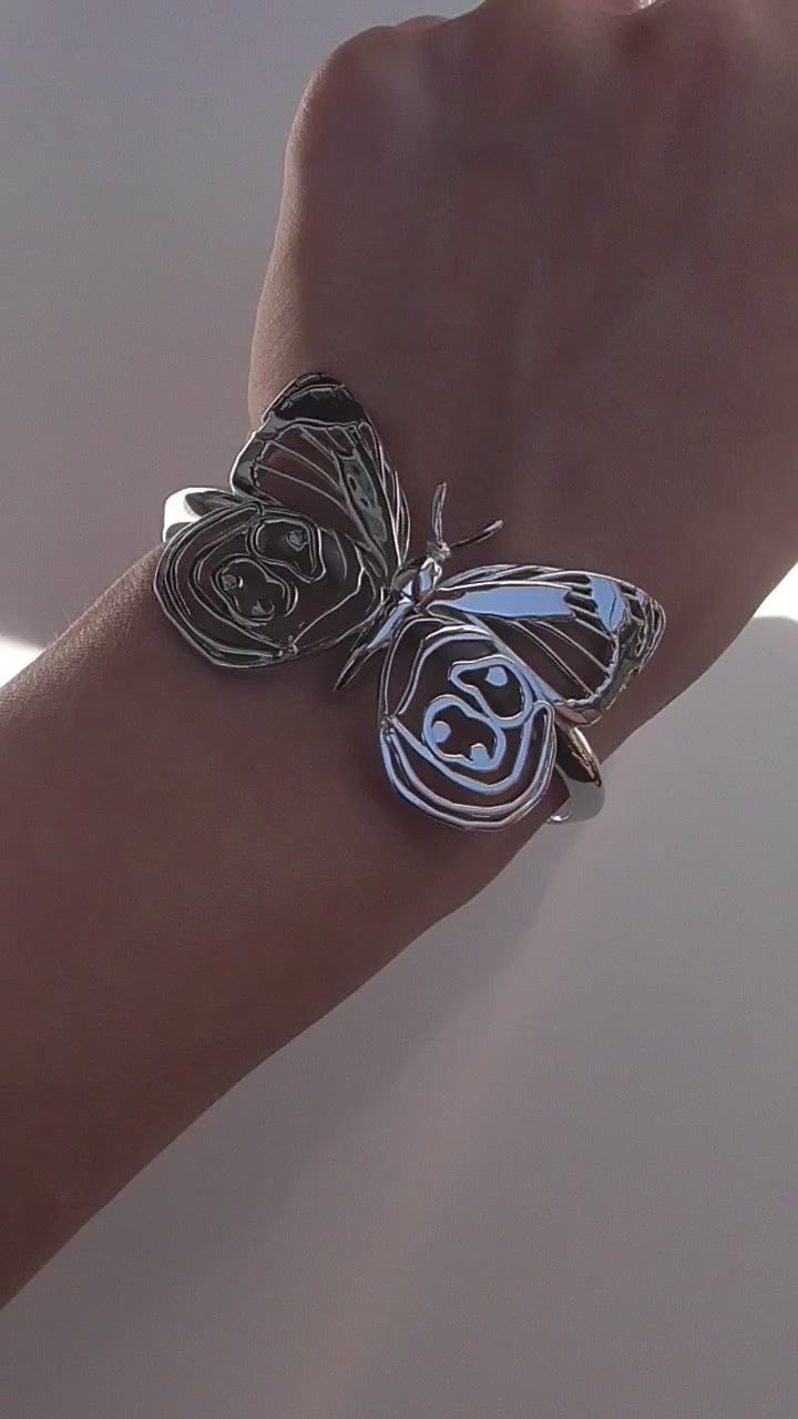 Video still of silver Eighty-eight Butterfly Bracelet on white background, highlighting sculptural wing detail.