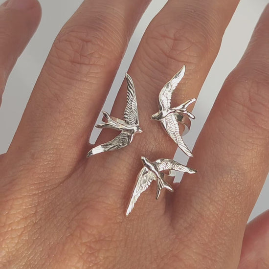 Video preview showing Swallow Gathering Ring worn on hand, capturing light reflections and the fluid motion of the sculpted birds.