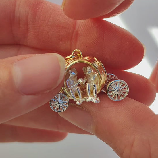Video showcase of the Frogs in Pumpkin Carriage Pendant, featuring two miniature frogs seated hand‑in‑hand inside a sculpted pumpkin carriage with freely spinning wheels and curling root details.