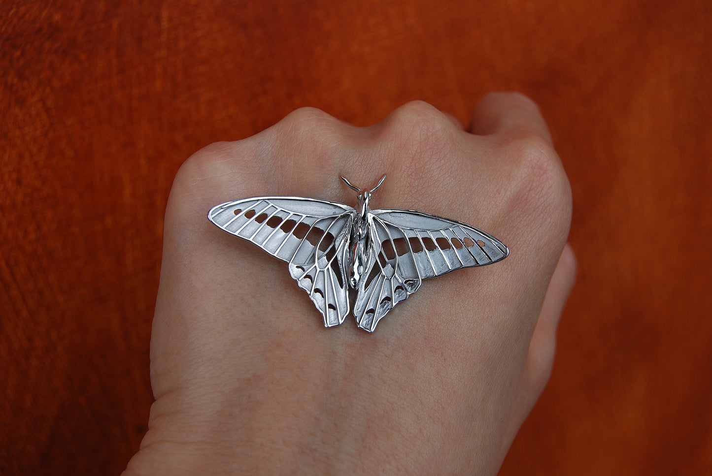 Back view of Blue Triangle Butterfly pendant in sterling silver, revealing smooth polished surface and sculpted form.