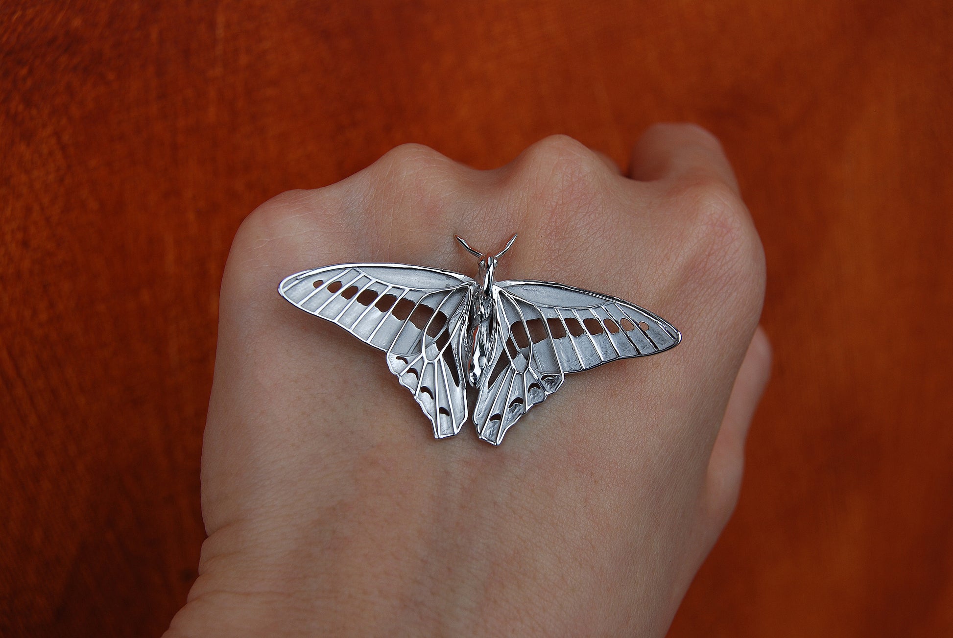 Back view of Blue Triangle Butterfly pendant in sterling silver, revealing smooth polished surface and sculpted form.