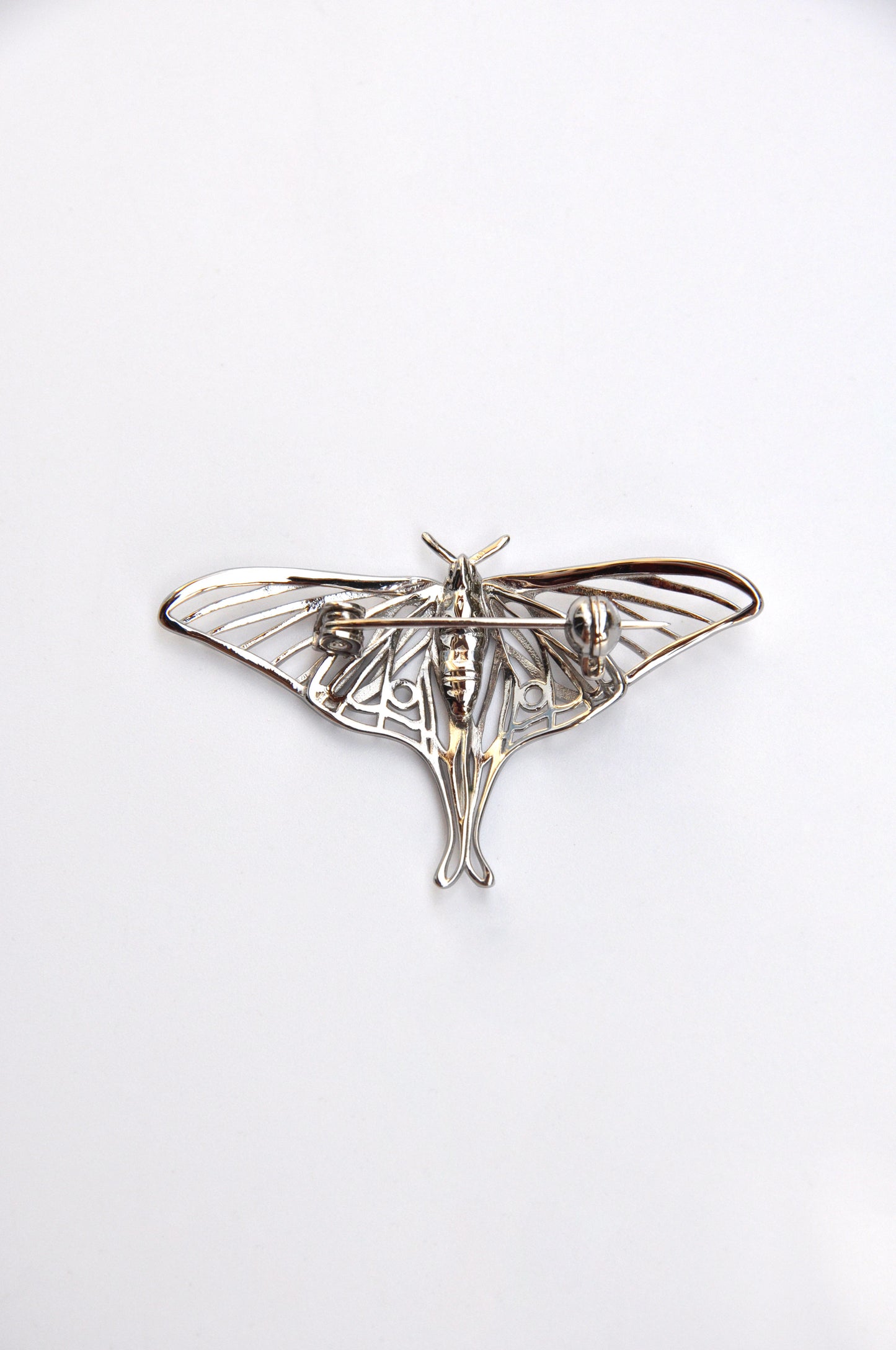 Back view of the silver Luna Moth brooch on a white background, highlighting the pin mechanism and finish.