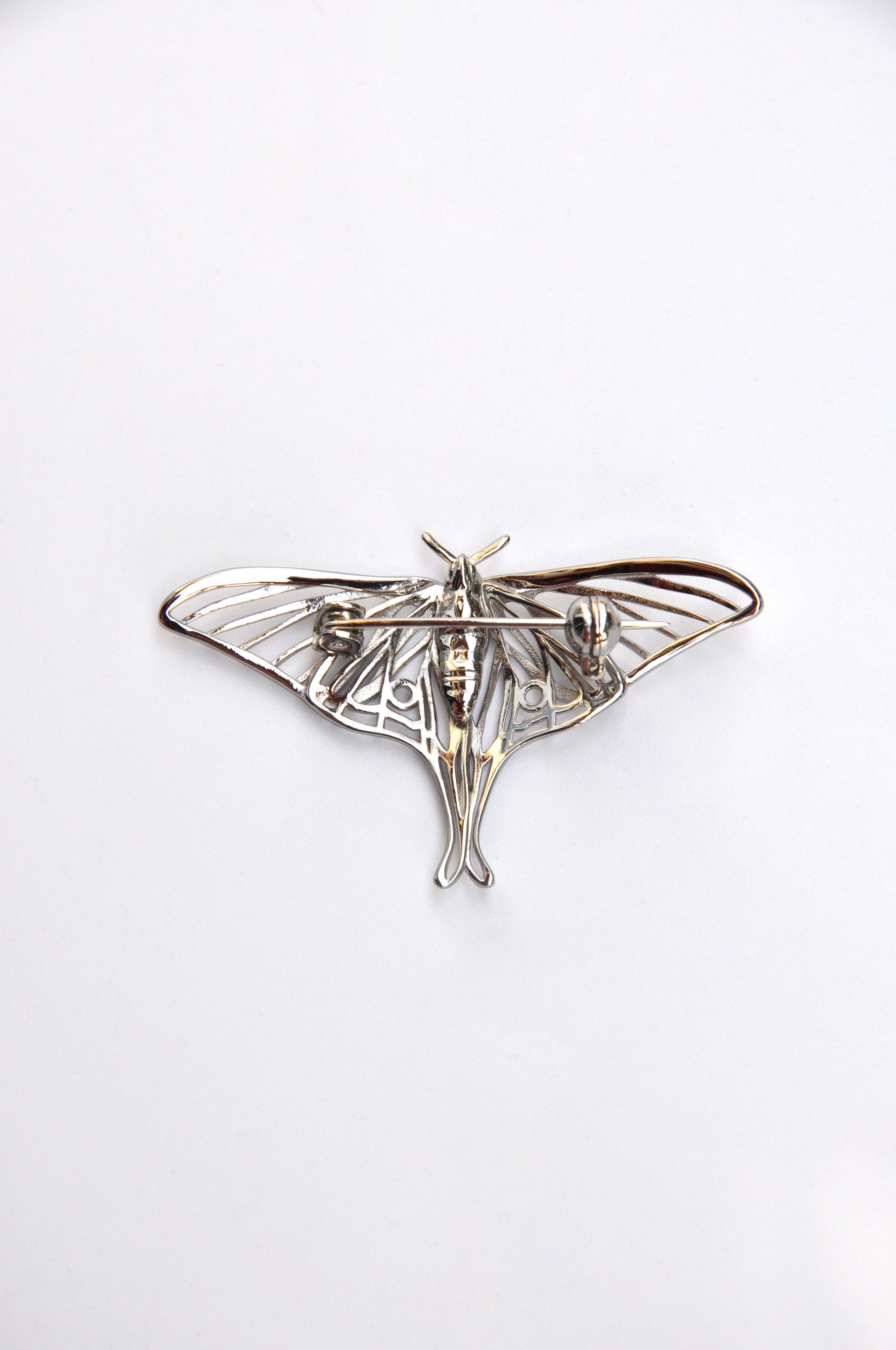 Back view of the silver Luna Moth brooch on a white background, highlighting the pin mechanism and finish.