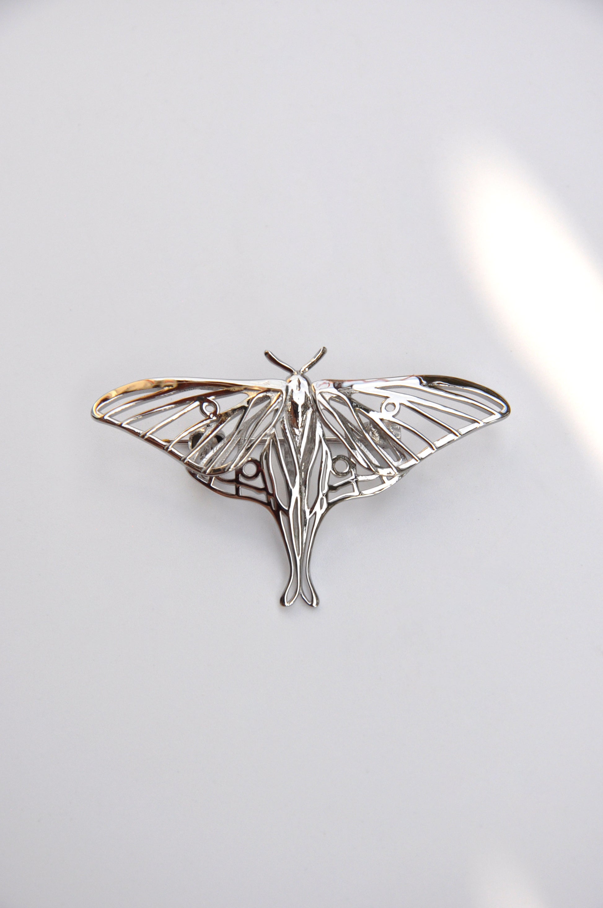 Front view of the silver Luna Moth brooch on a white background, showcasing detailed wings and craftsmanship.