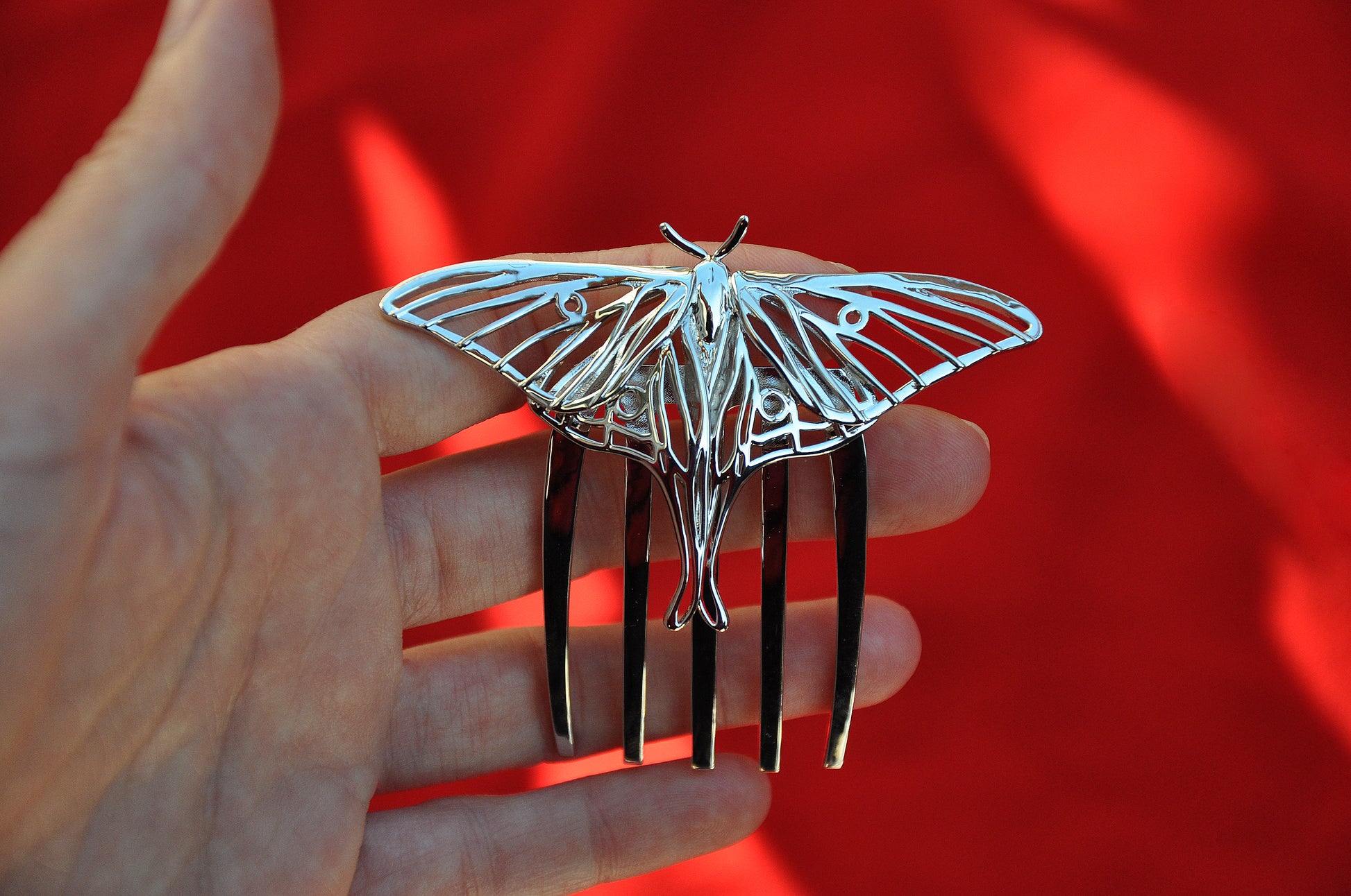 Front close-up of silver Luna Moth hair comb highlighting its delicate wing cutouts and handcrafted insect jewelry design in a polished silver finish.