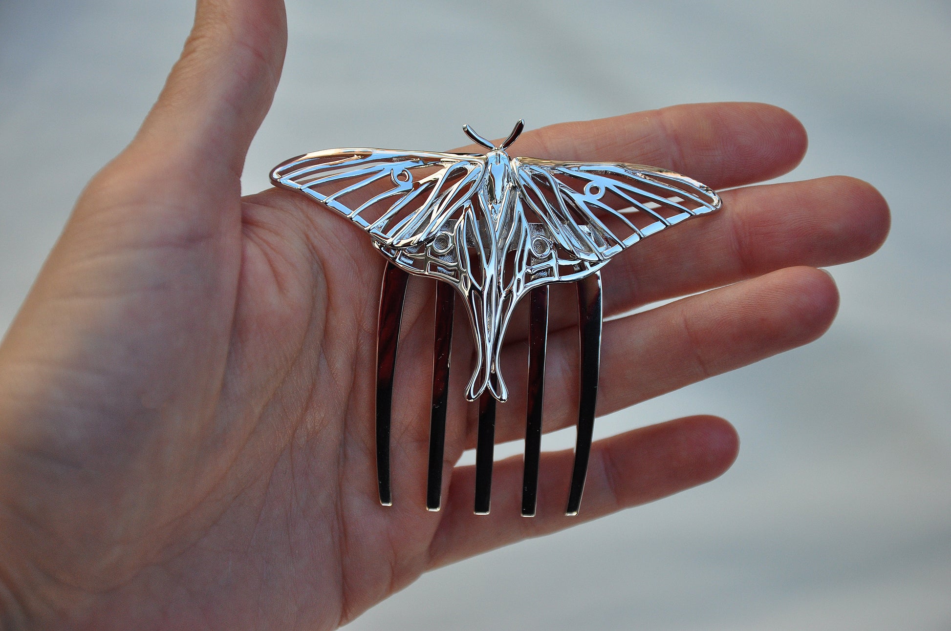 Front view of silver Luna Moth hair comb showcasing detailed wing cutouts and elegant insect-inspired design, handcrafted as nature-themed hair jewelry.