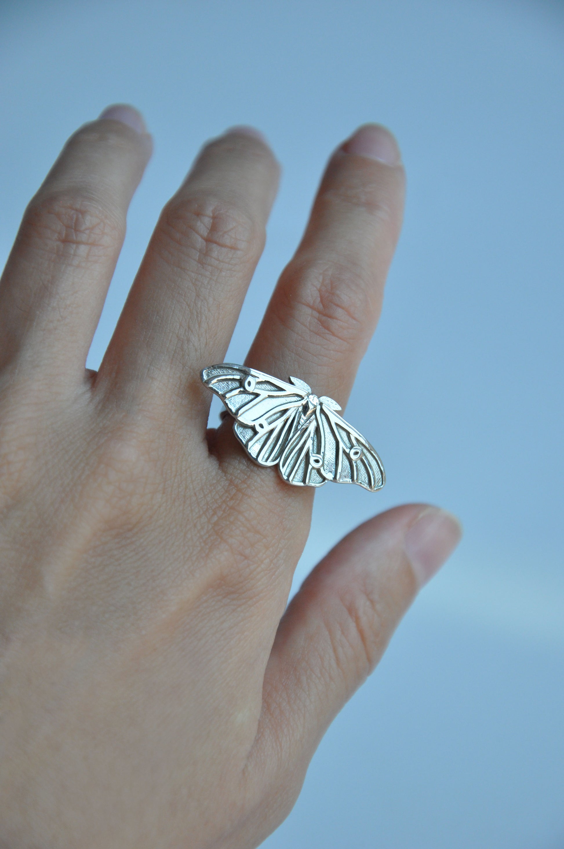 Ethereal silver moth ring featuring intricate silk moth design, unique bug jewelry gift