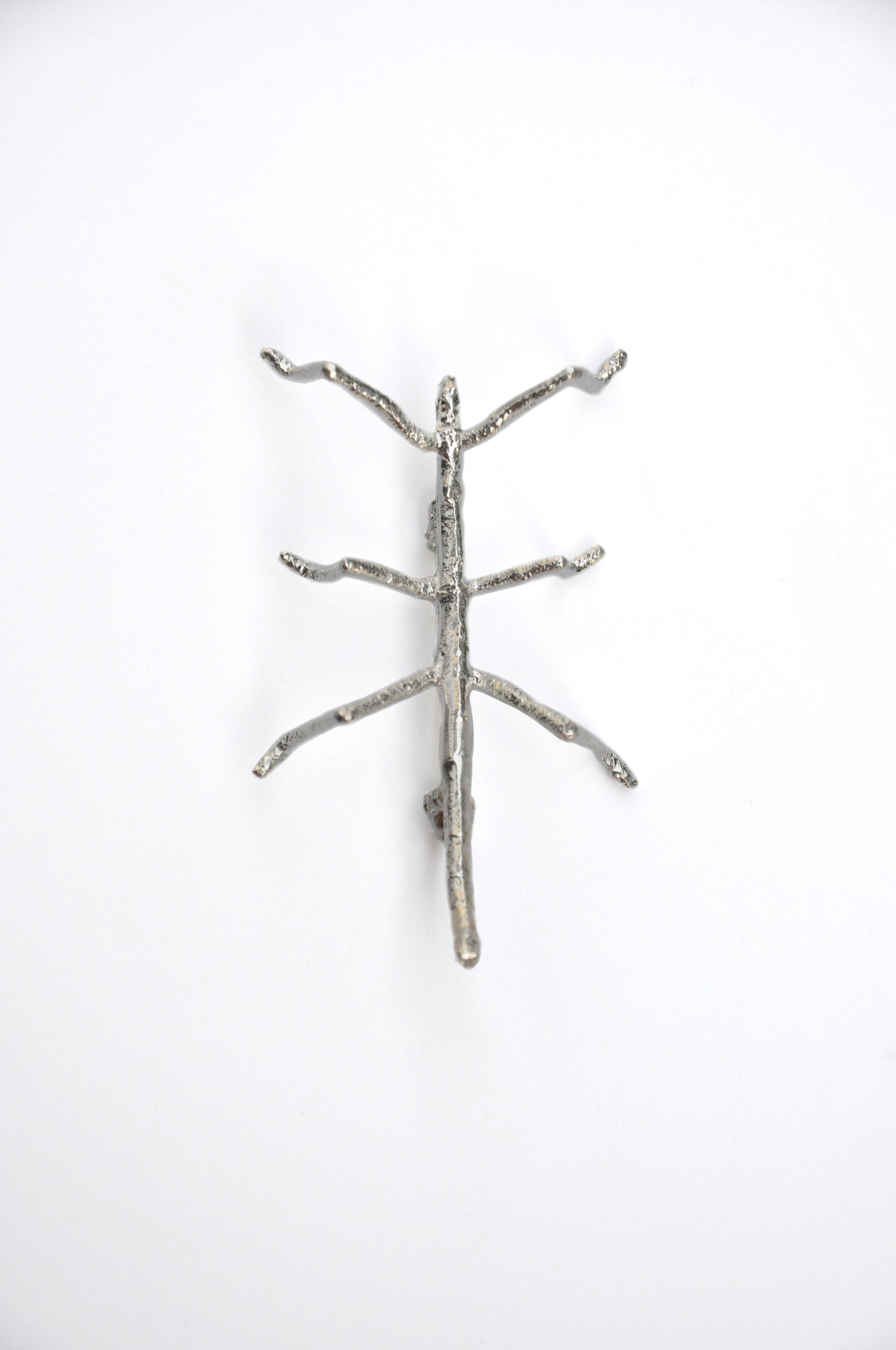  Front view of the silver stick insect brooch on a white background, showing intricate detail and texture.