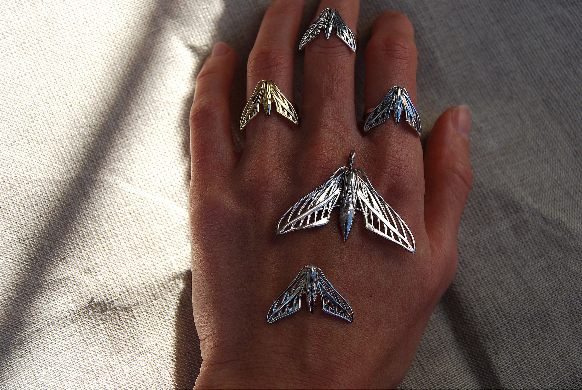 
Final view of full sphinx moth ring collection in silver and gold worn on hand, highlighting handcrafted celestial design.