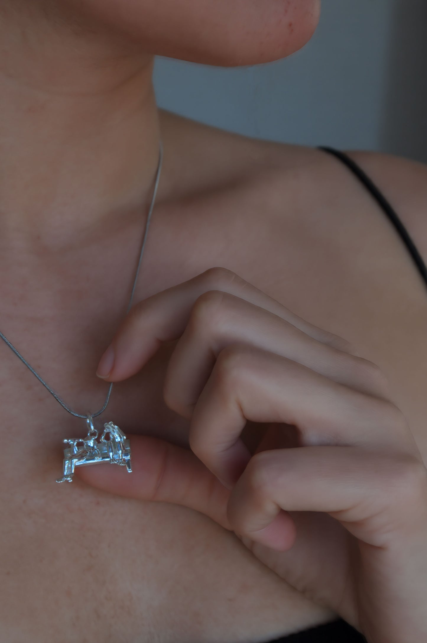 Stargazer Frogs Pendant worn on a neck, showing two miniature frogs in a sculptural scene of shared curiosity.
