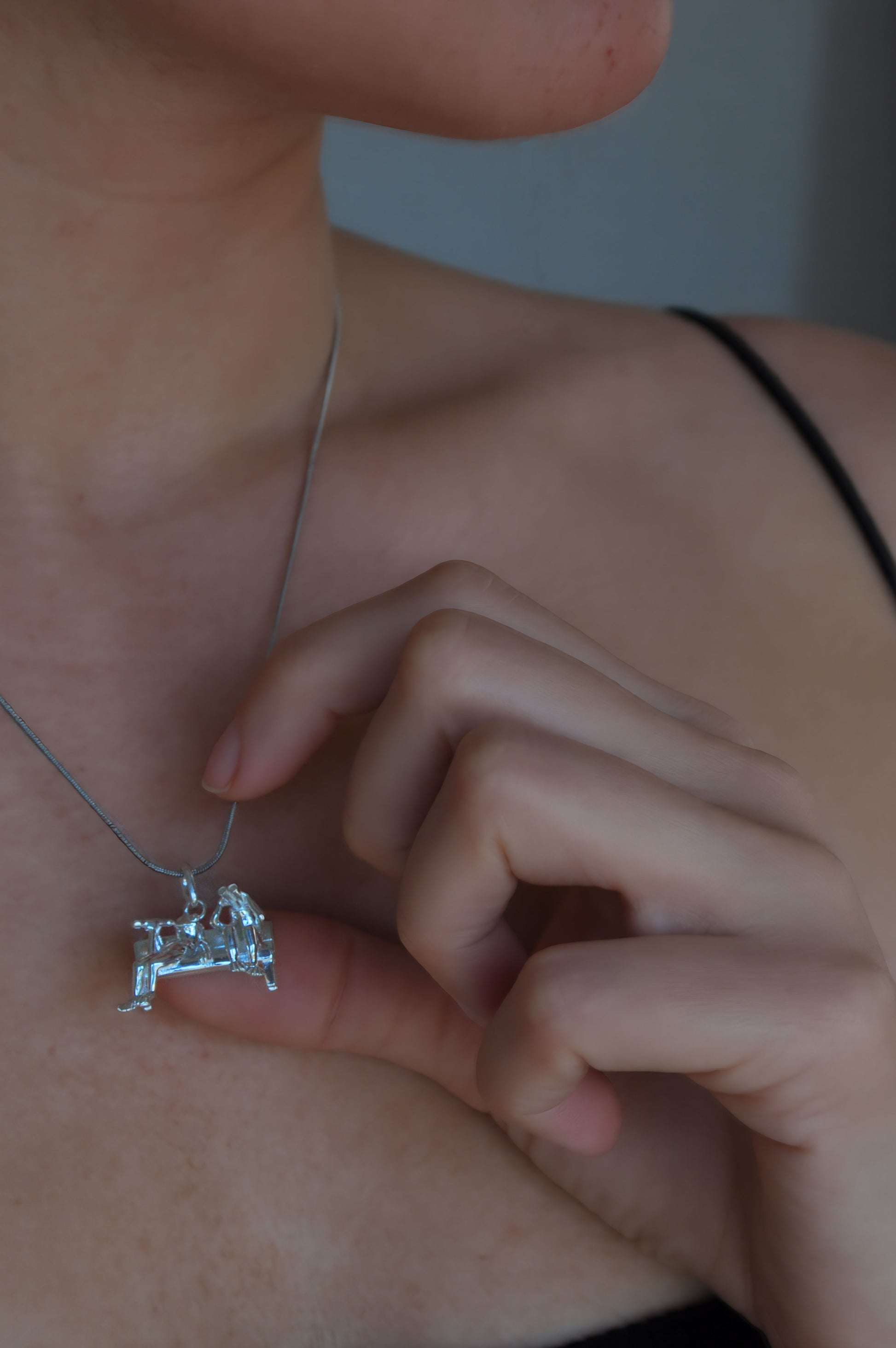 Stargazer Frogs Pendant worn on a neck, showing two miniature frogs in a sculptural scene of shared curiosity.
