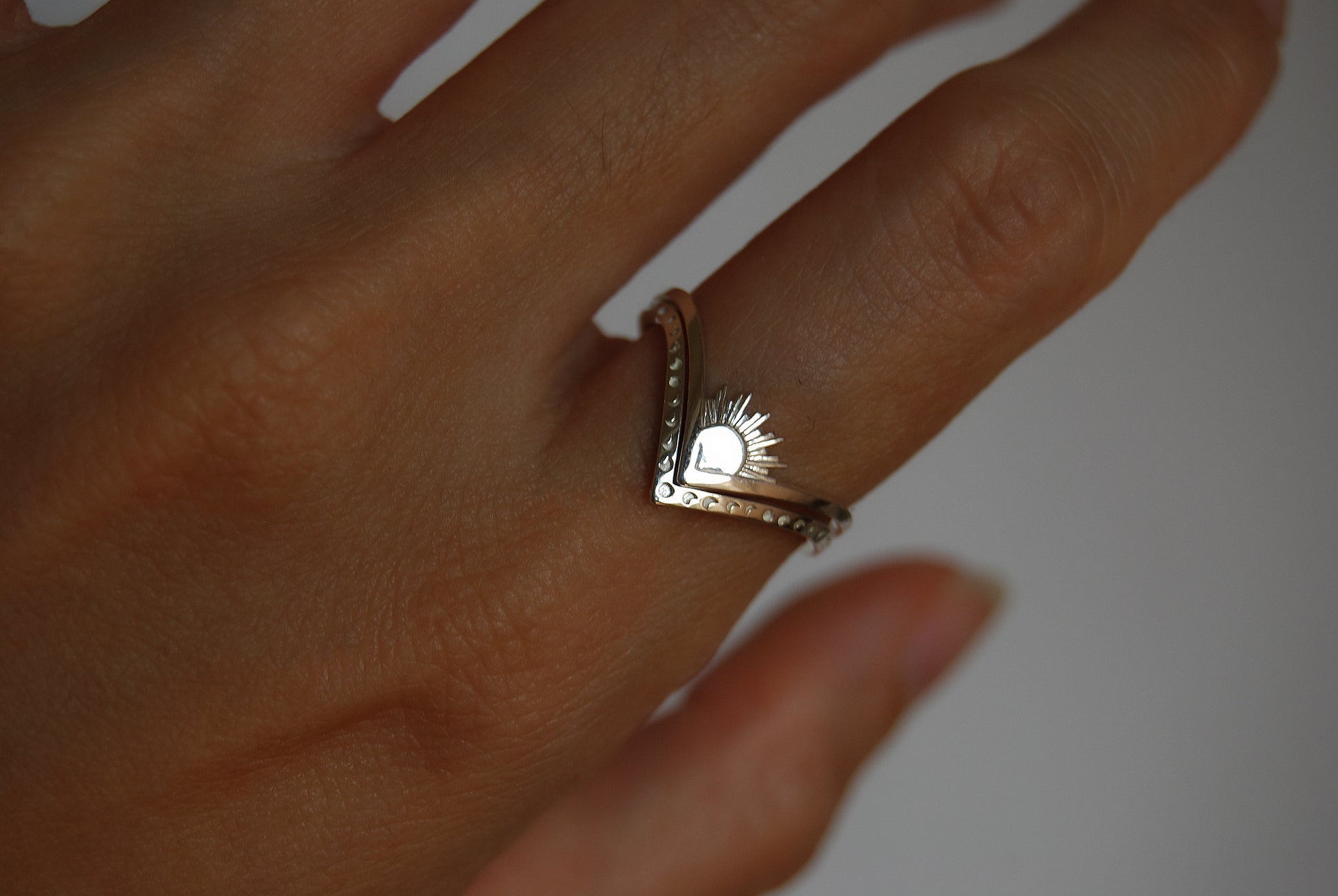 Sun and moon chevron rings stacked in opposite directions, emphasizing cosmic duality in celestial jewelry.