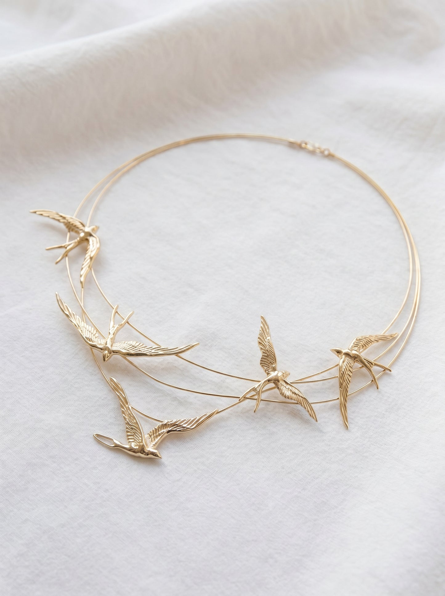 Gold‑plated necklace with sculpted swallows in flight along fine arcs, inspired by Art Nouveau elegance.