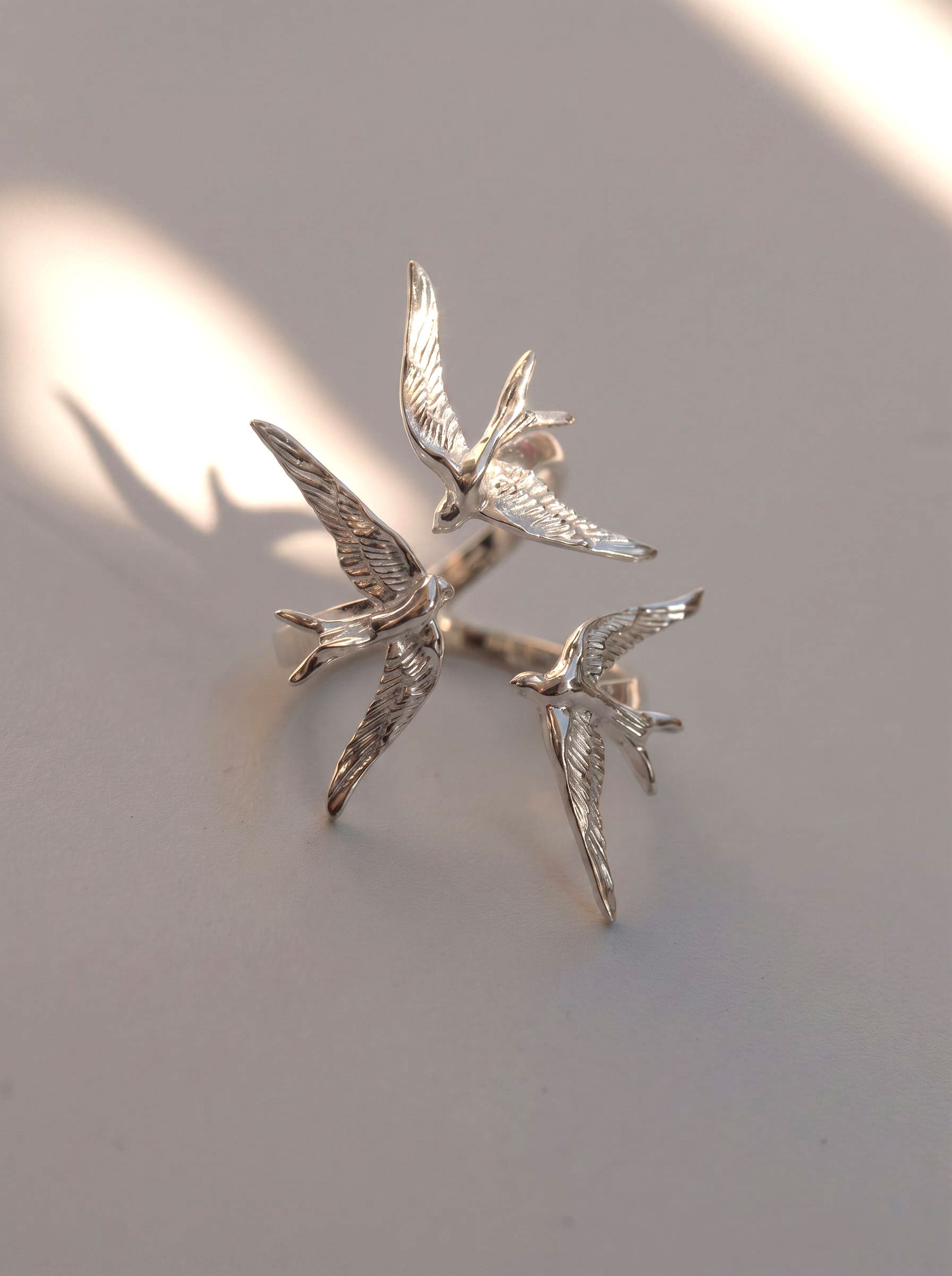 Swallow Gathering Ring photographed with soft shadows, emphasizing sculptural geometry and Art Nouveau inspiration.